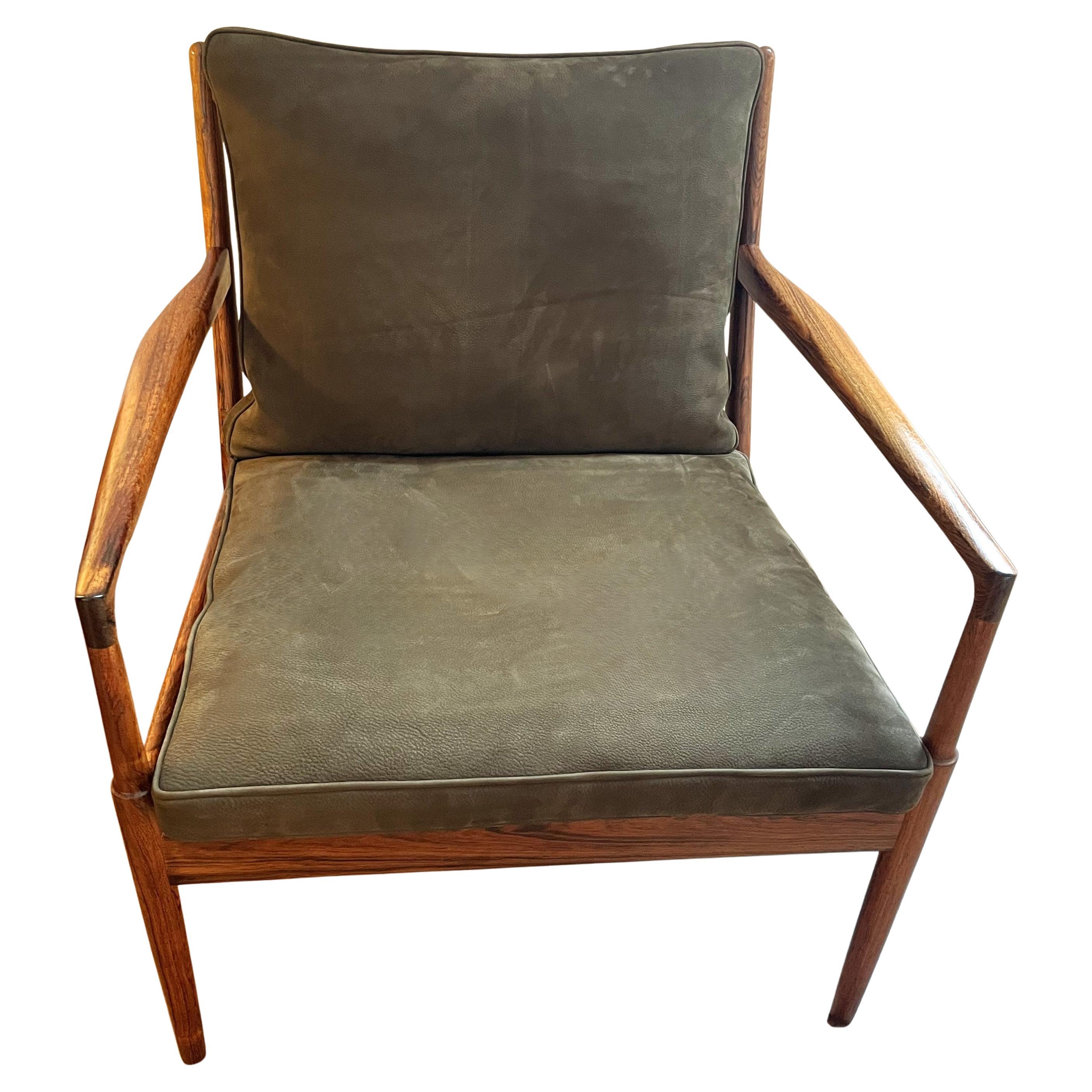 Beautiful pair of solid rosewood lounge chairs, with a warm and expressive grain that reinforces the lightness and organic character of the design and whose cushions, in original feather, have been covered with a beautiful bronze-coloured nubuck