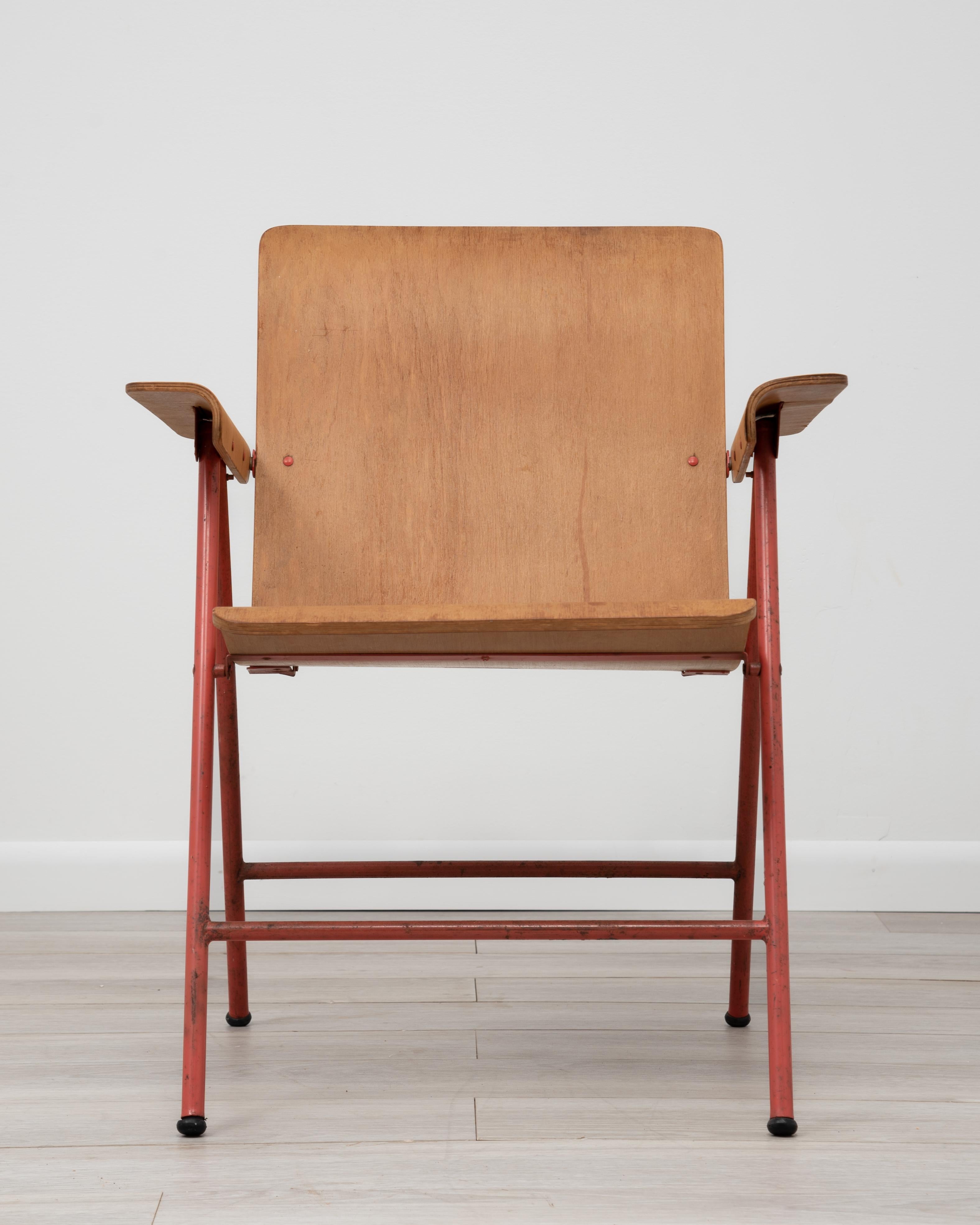 A single plywood and salmon color enameled iron folding armchair designed by Russel Wright for Shwayder Bros Inc. Signed with decal manufacturer's label to underside: [Samson Chairs Made in USA Shwayder Bros. Inc Samson Folding Tables Samsonite