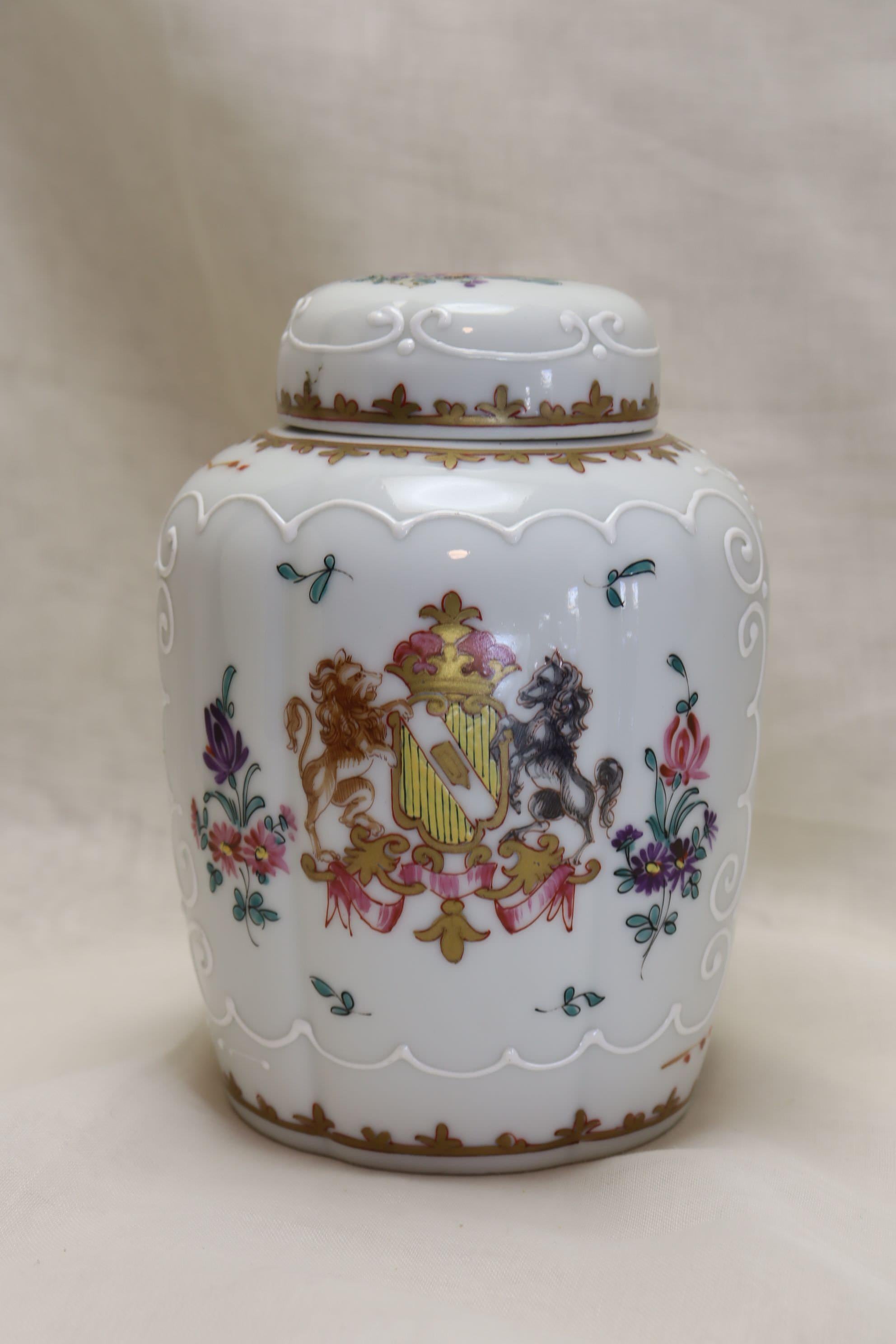 This hand painted and gilded tea canister is by Samson of Paris and is decorated with a faux armorial coat of arms on one side, and on the other with an expansive spray of flowers. The lid is also decorated with a floral spray. The decoration of the