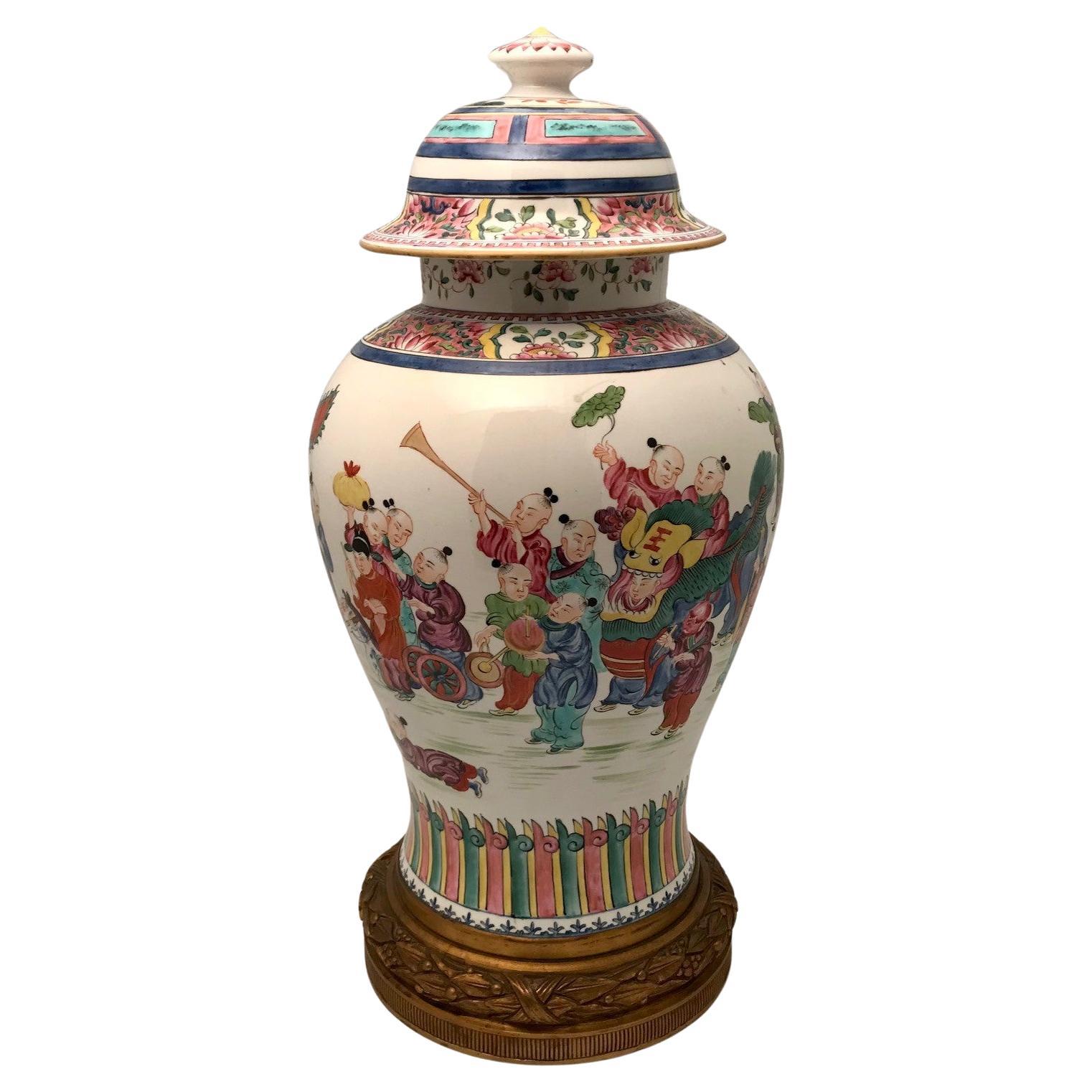 This Baluster vase is charmingly painted in polychrome with a procession, children playing, with adults playing musical instruments, riding on a cart and with a dragon. The overall feel is festive. and playful..