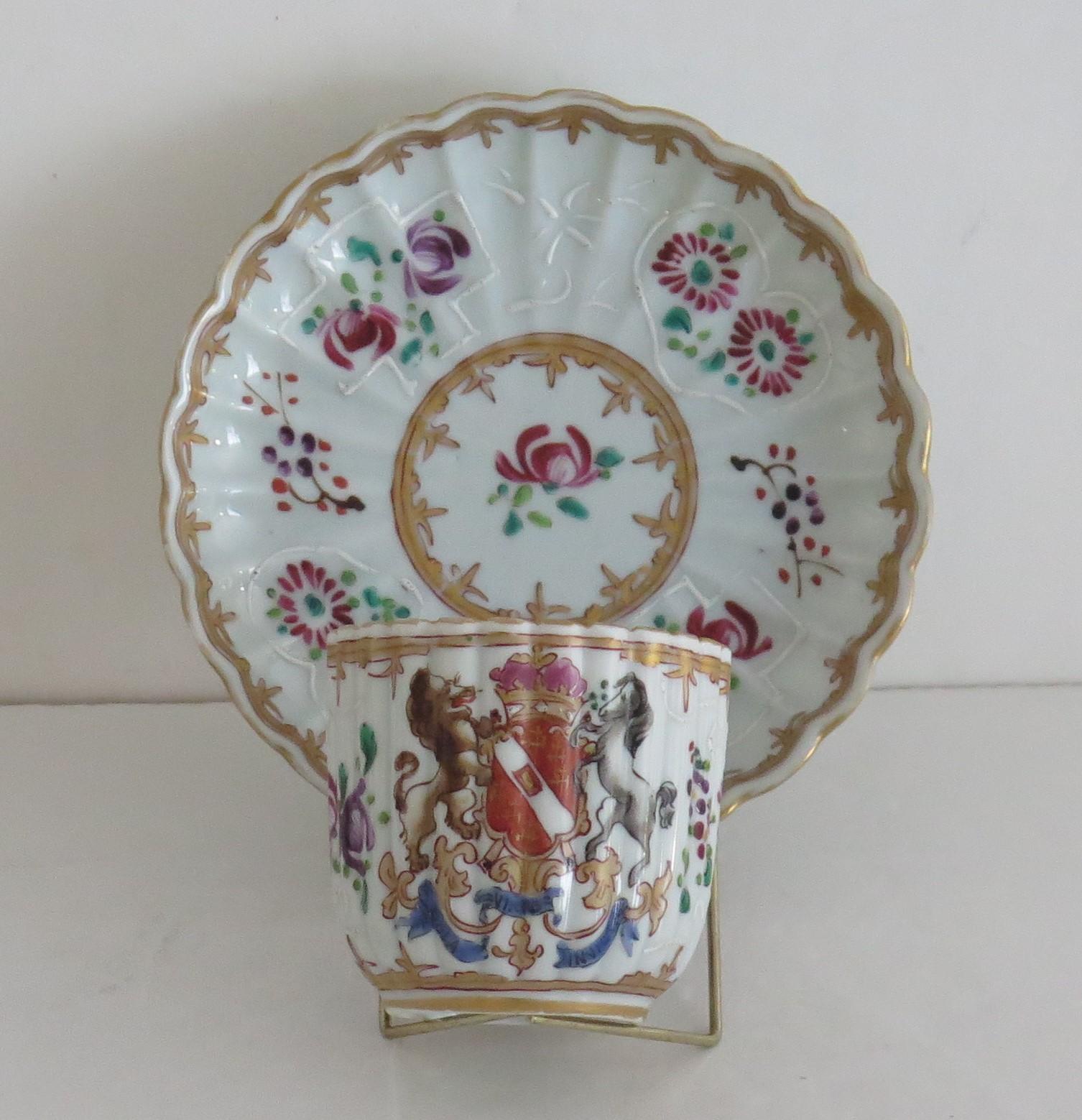 This is a very good fluted porcelain armorial tea cup and saucer in the Chinese taste with an Armorial lion and horse supporting a shield above a legend, made by Samson, Paris, France. 

 Edme Samson, Paris, circa 1860 - 1880. EdmeSamson of Paris