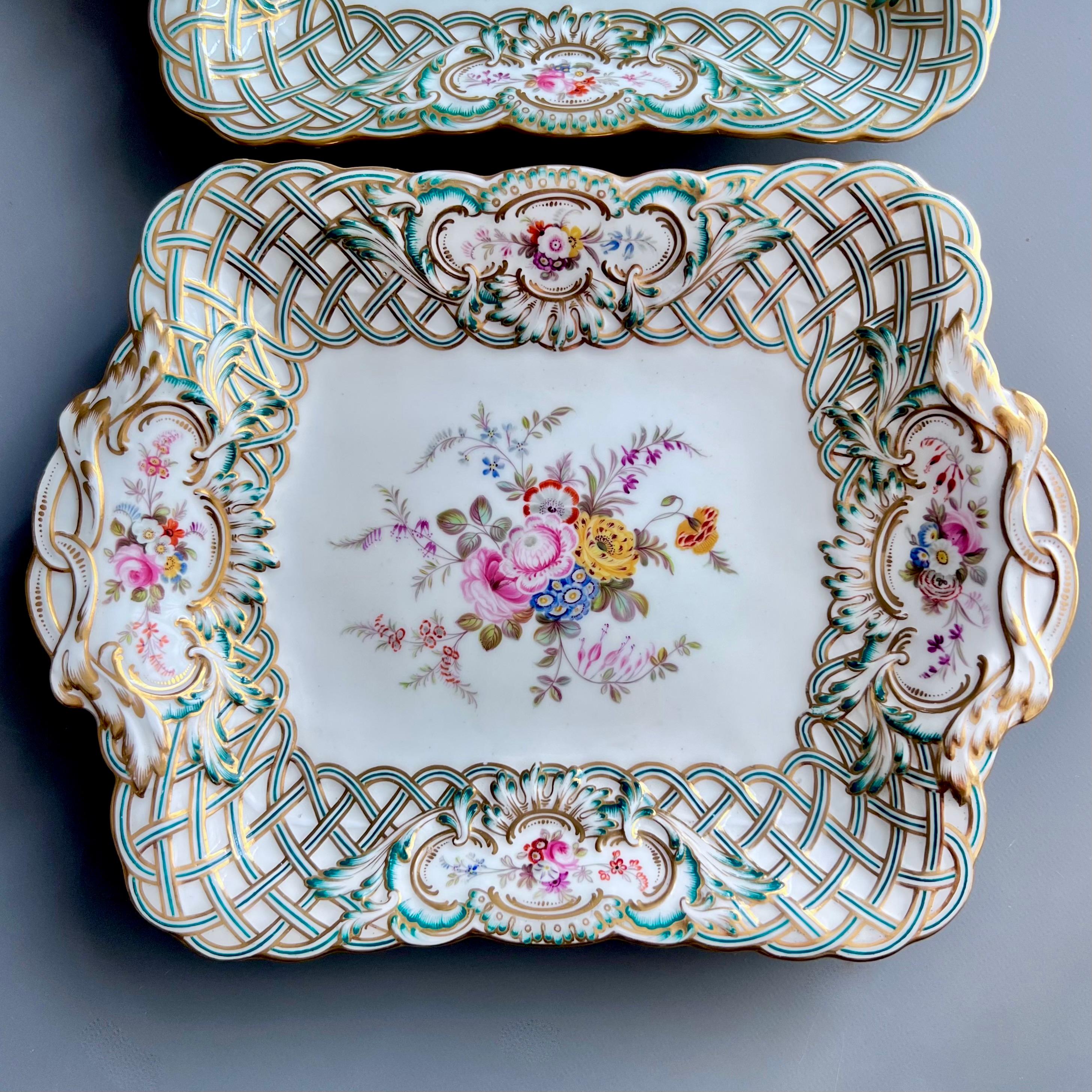 This is a stunning pair of rectangular dishes made by Minton in 1857. The dishes are beautifully moulded in the Newcastle Embossed shape, the moulding picked out and turquoise and gilt, and hand painted with flowers by Joseph Bancroft. These dishes