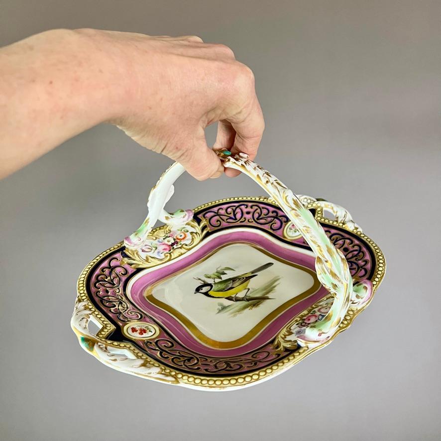 A large basket with a Persian-inspired moulded Alma border in black on a bright pink ground, a moulded swan-head handle in white, gilt and pale green, pierced ends and a beautiful painting of a great tit in the centre

Pattern 3/7978
Year: