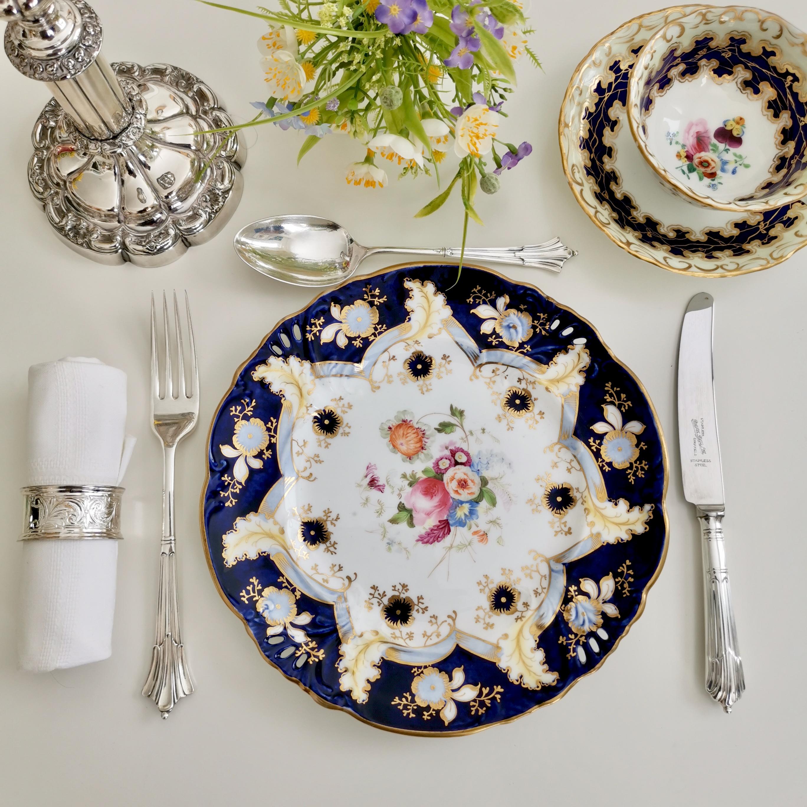 This is a beautiful dessert plate made by Samuel Alcock around the year 1845 during Rococo Revival era. The plate is decorated in cobalt blue, gilt and beautiful flowers, and has a 