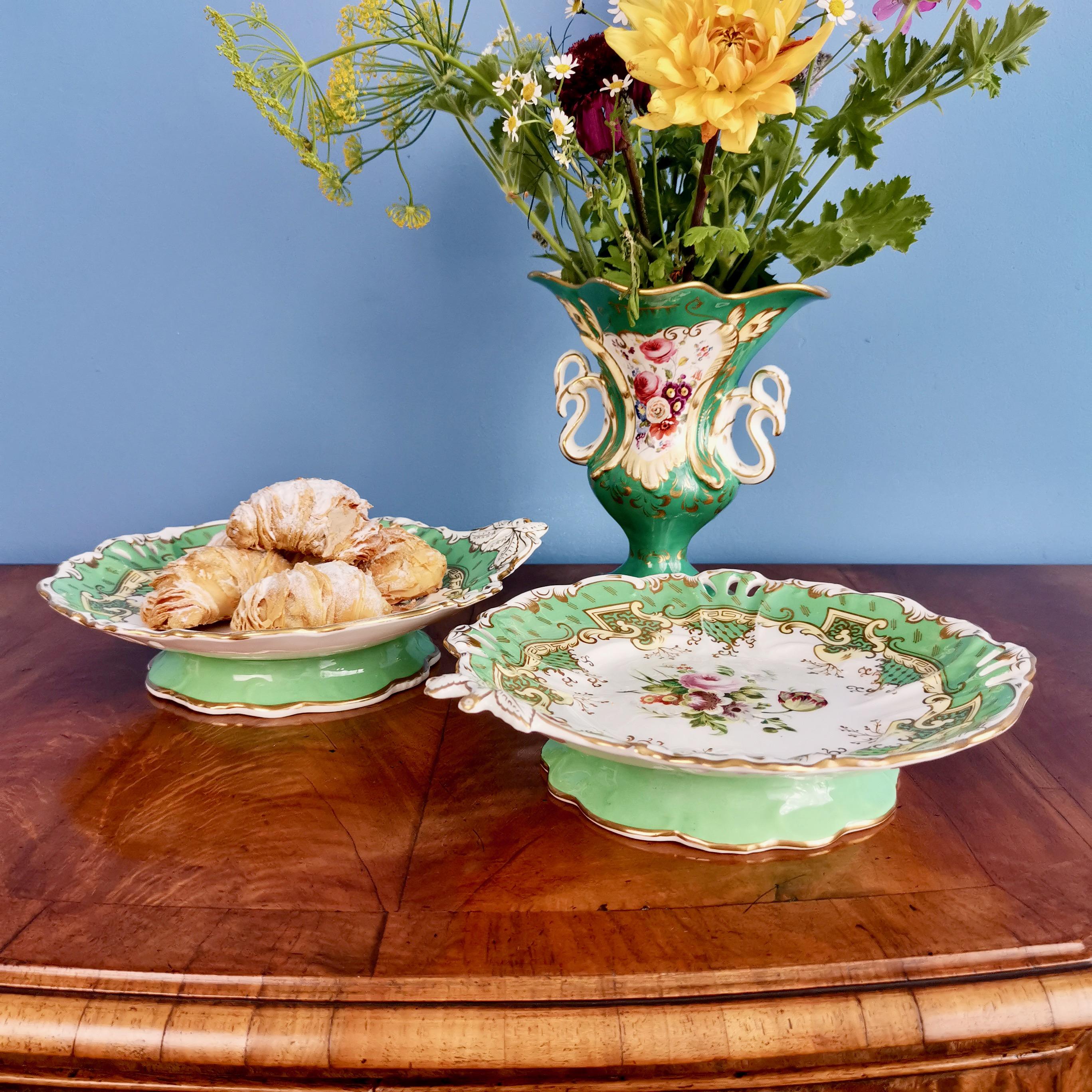 This is a beautiful set of two low porcelain comports made by Samuel Alcock around the year 1835, which was the beginning of the Victorian era. The comports have an emerald green ground, pierced 