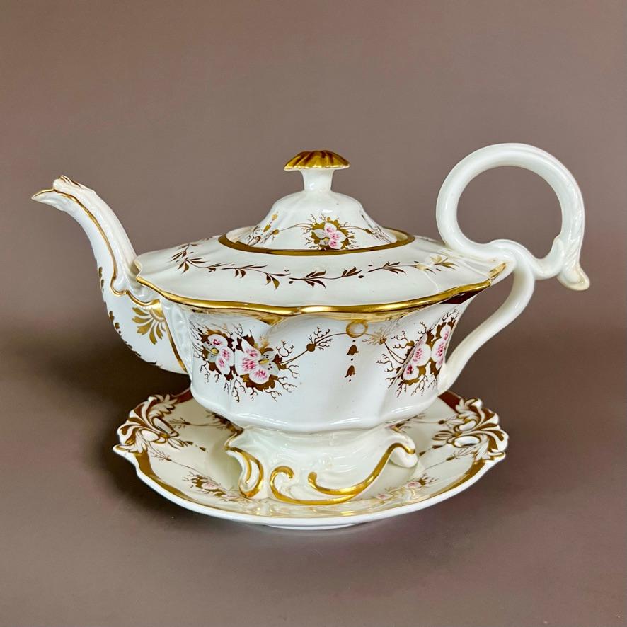 A beautiful solitaire tea set consisting of a teapot with cover on a stand, a sucrier with cover, a milk jug, a cake plate and a trio consisting of a teacup, a coffee cup and a saucer. In “writhen” shape with white ground and gilt, and charming
