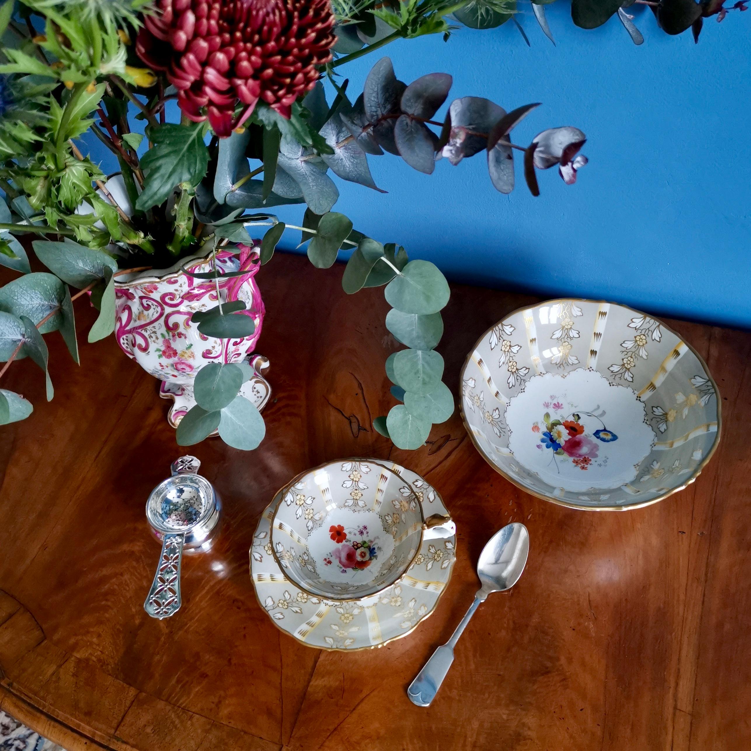 This is a beautiful teacup and saucer made by Samuel Alcock circa 1845, which was the Rococo Revival era. The cup and saucer are decorated with a grey striped pattern and hand painted flowers.

I have a slop bowl available in the same pattern,