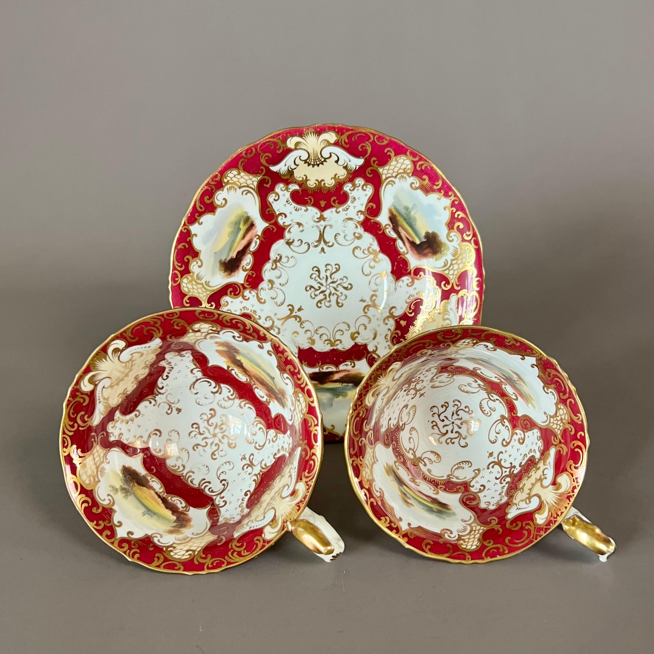 A true trio consisting of a teacup, a coffee cup and a saucer, “rustic bean” shape, in deep maroon and pale yellow ground, with gilt and finely painted landscape reserves

Pattern 9508
Year: ca 1845
Size: teacup 10.5cm (4.25”), coffee cup 9cm