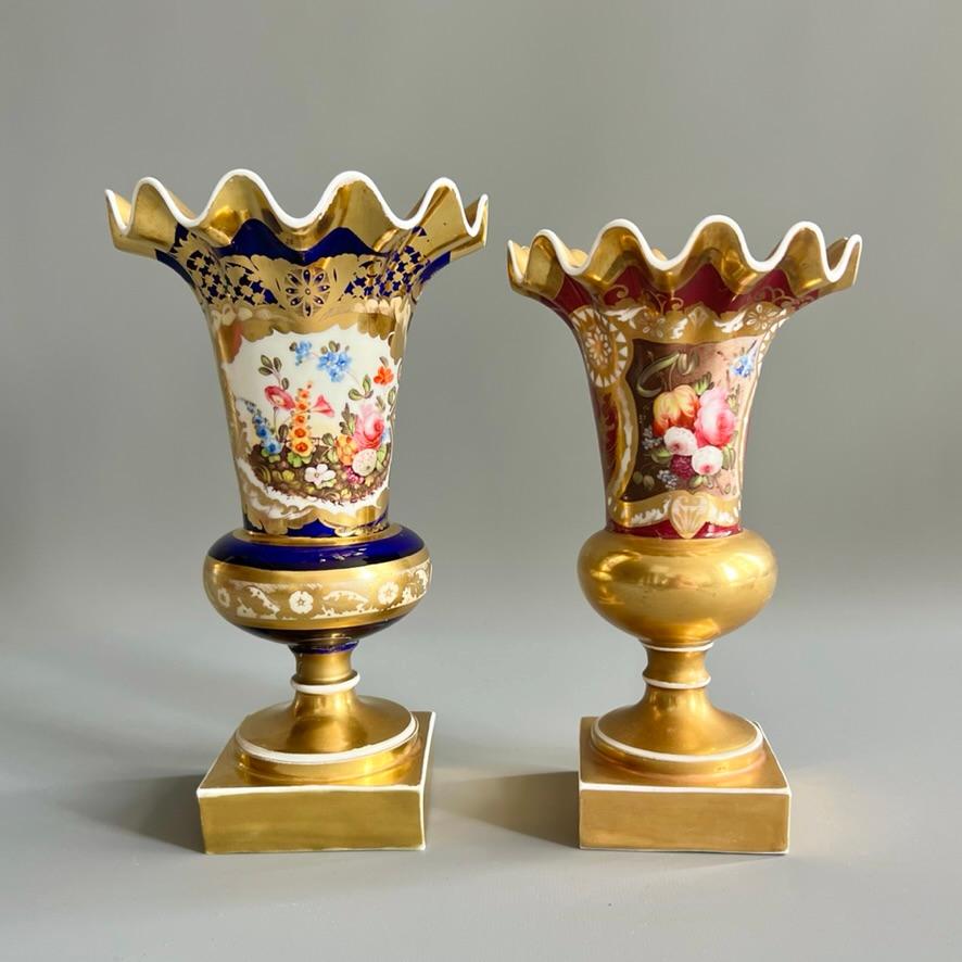 Jarrón de borde ondulado en granate oscuro y rica decoración dorada, con una reserva finamente pintada con una escena floral de jardín en la parte delantera; rico dorado en el borde superior, bola, pie cuadrado y finos motivos dorados