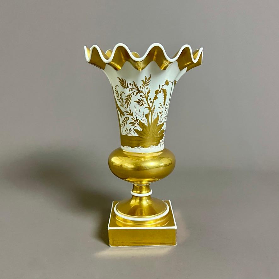 A very rare wave-edge vase with a gilt Chinoiserie scene of a woman in a garden on a white ground; rich gilding on upper edge, ball and square foot.

Pattern 1035
Year: ca 1825
Size: 19.5cm tall (7.75”)
Condition: stem has been well repaired, some