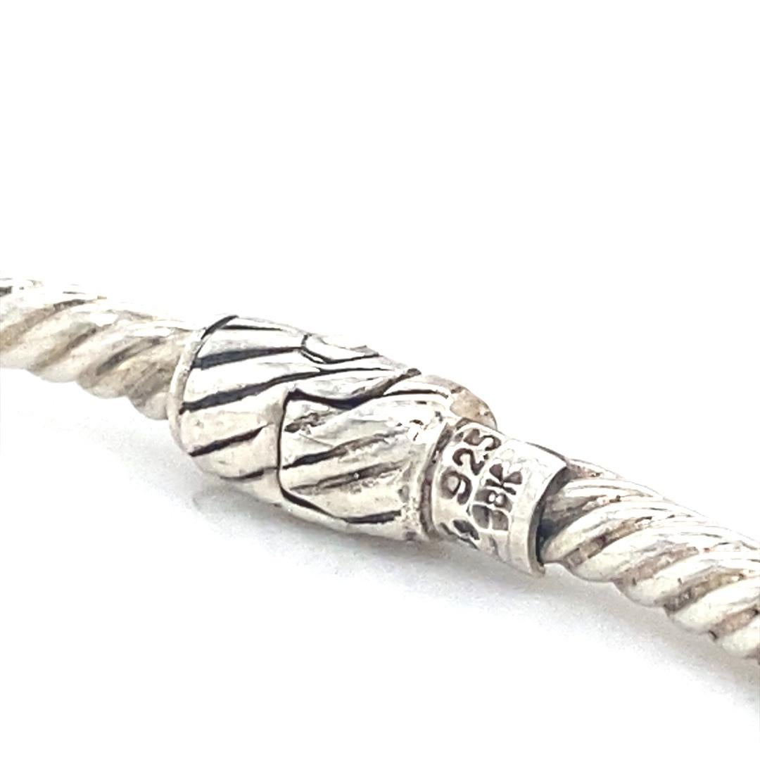 Dieses atemberaubende Armband wird von Samuel B. aus Sterlingsilber mit 18-karätigen Akzenten hergestellt. Sie ist 3 mm breit und passt an ein Handgelenk von bis zu 7 Zoll. Es gibt zwei kissenförmige Londoner Blautopas-Steine. Dieses Armband ist das