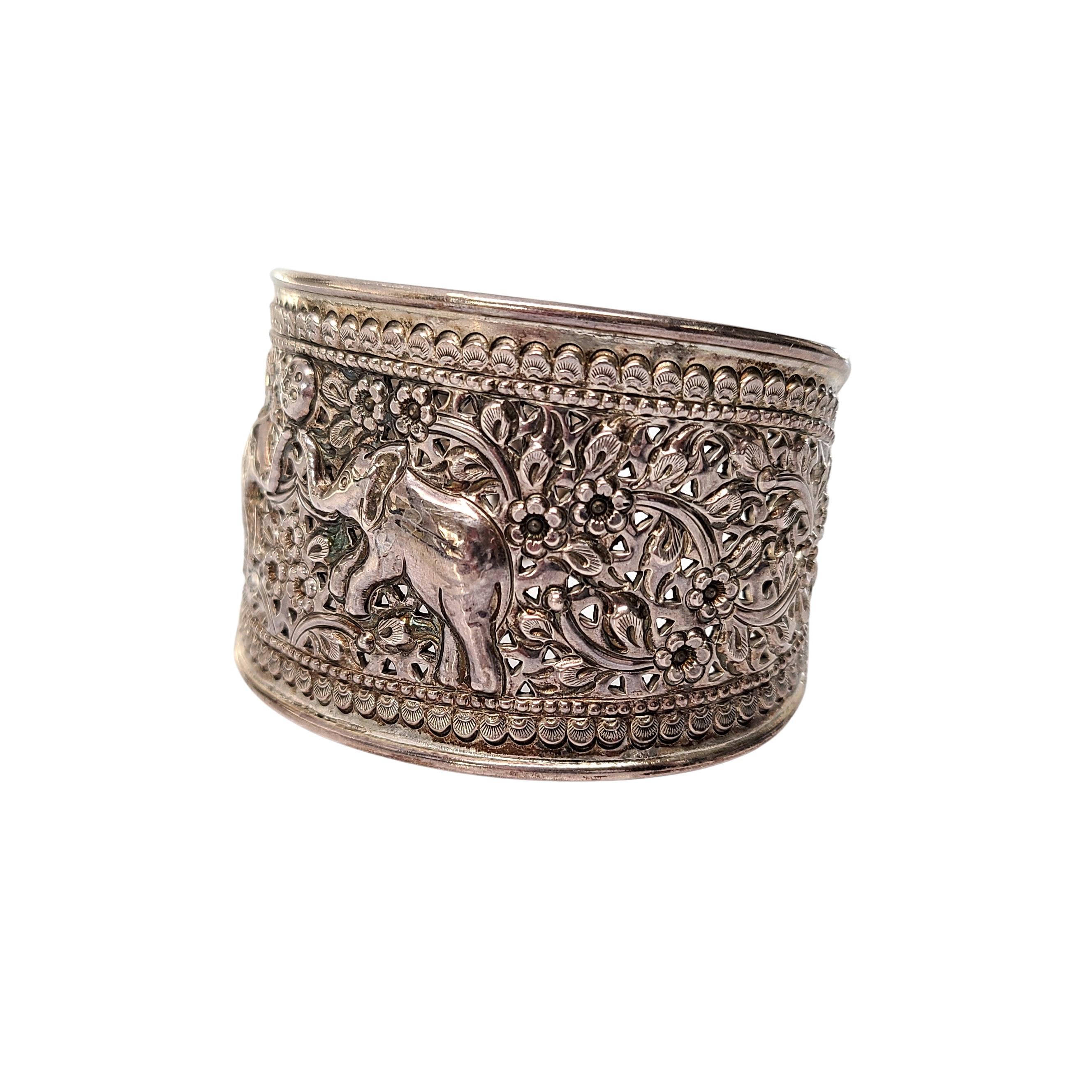 Sterling silver wide elephant cuff bracelet by designer Samuel Benham (BJC).

Beautiful repousse design os 2 elephants playing with a ball on a floral background. 

Measures approx 7