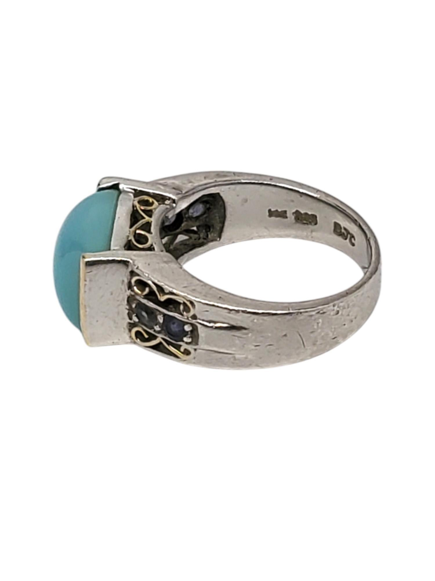 Samuel Benham Sterling Silver & 14K Gold Plate Chalcedony Ring 

This ring features a large rectangular Chalcedony stone (10.2 mm x 12.8 mm) with purple accent stones set in a sterling silver & a gold tone bezel by Samuel Benham.

Shank: 4.01