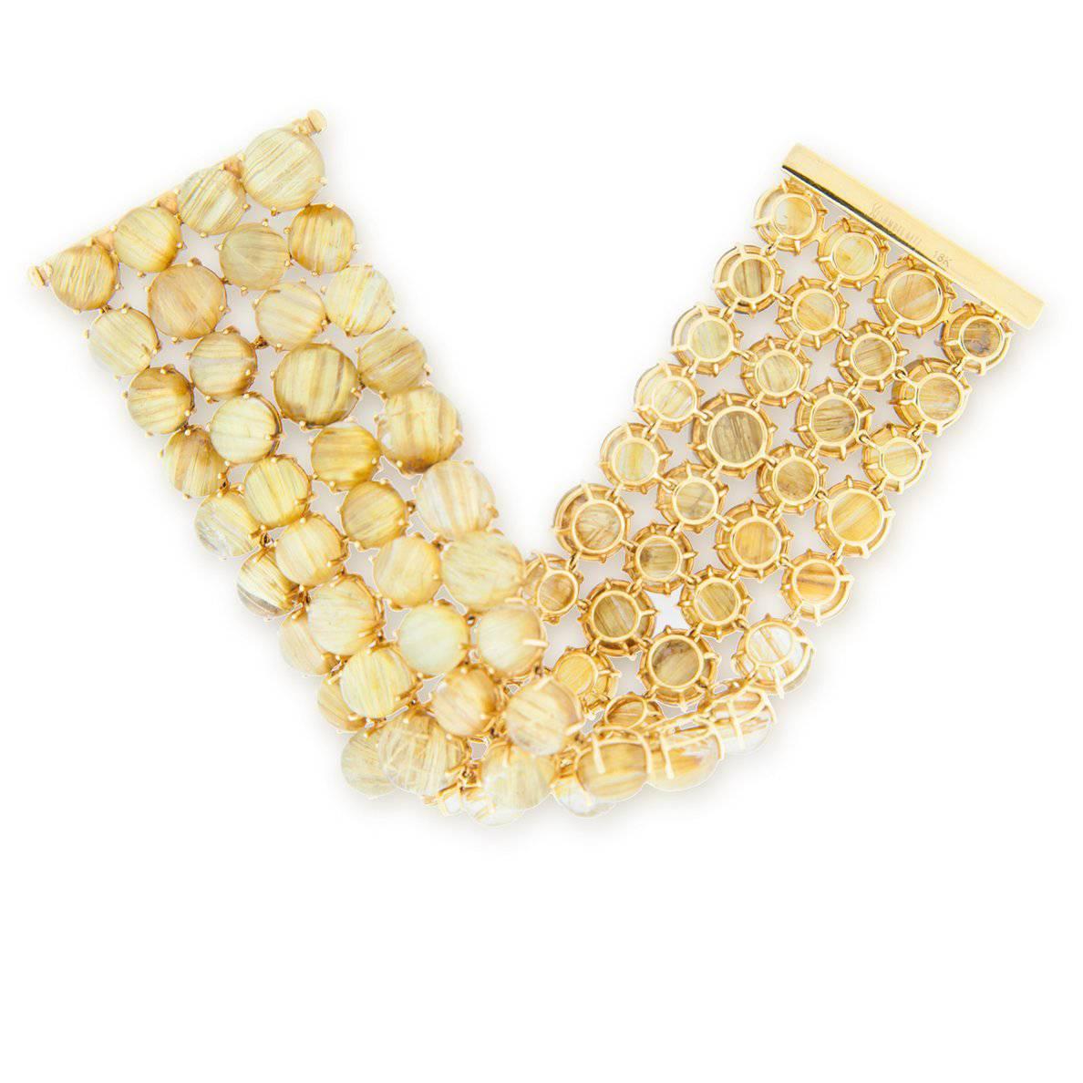 A "Samuel Getz" 18 Karat Yellow Gold Bracelet Featuring [75] Cabochon Shaped Yellow Rutilated Quartz Cat's Eyes with a Total Weight of 314.04 Carats.
(Stamped: 18KT, SAMUEL GETZ).

This Bracelet is highly flexible making it very