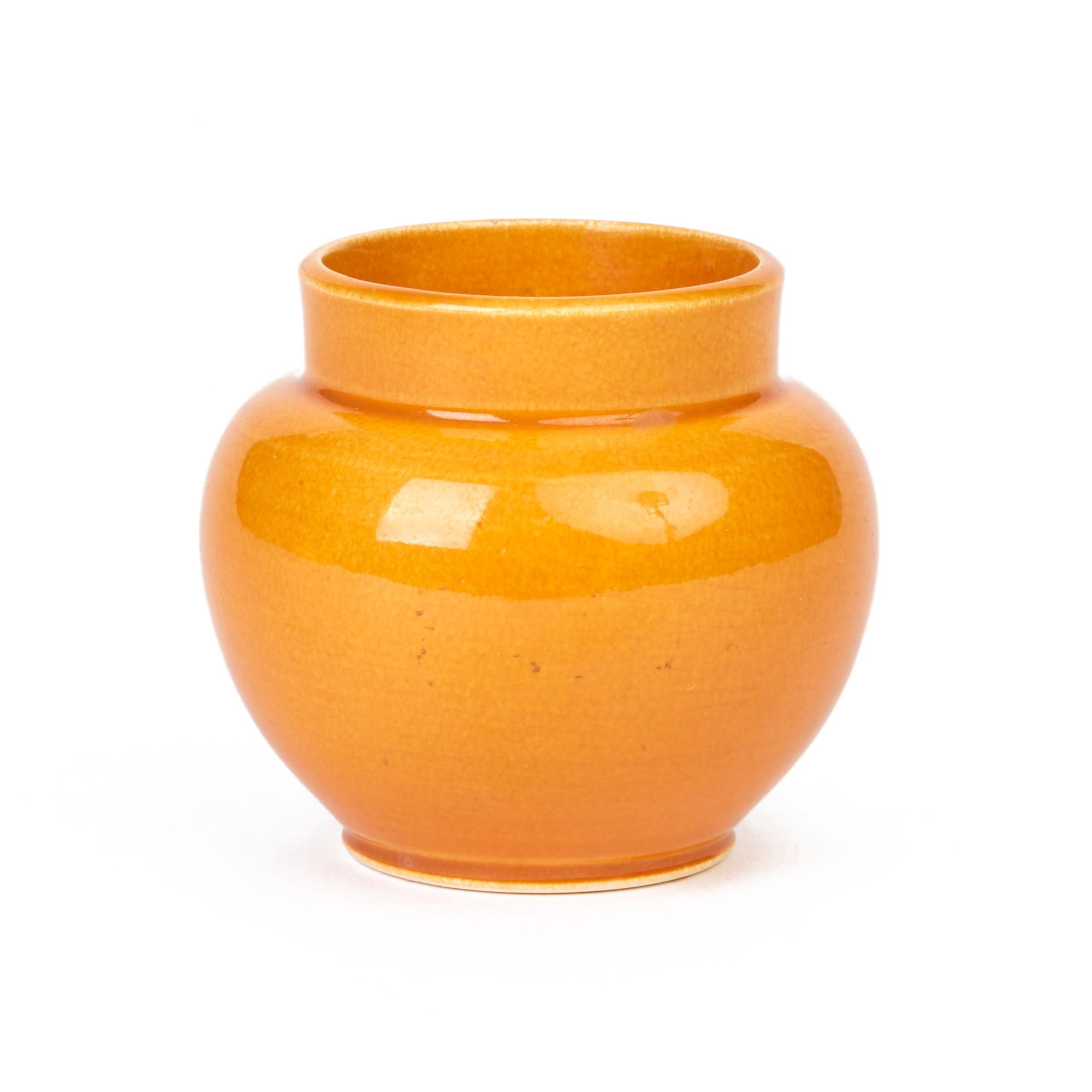 A rare English Arts & Crafts miniature art pottery vase by Samuel Lear decorated in orange Majolica glazes. The small rounded bulbous vase stands on a narrow rounded foot with a short funnel shaped top. The vase is decorated in bright orange glazes