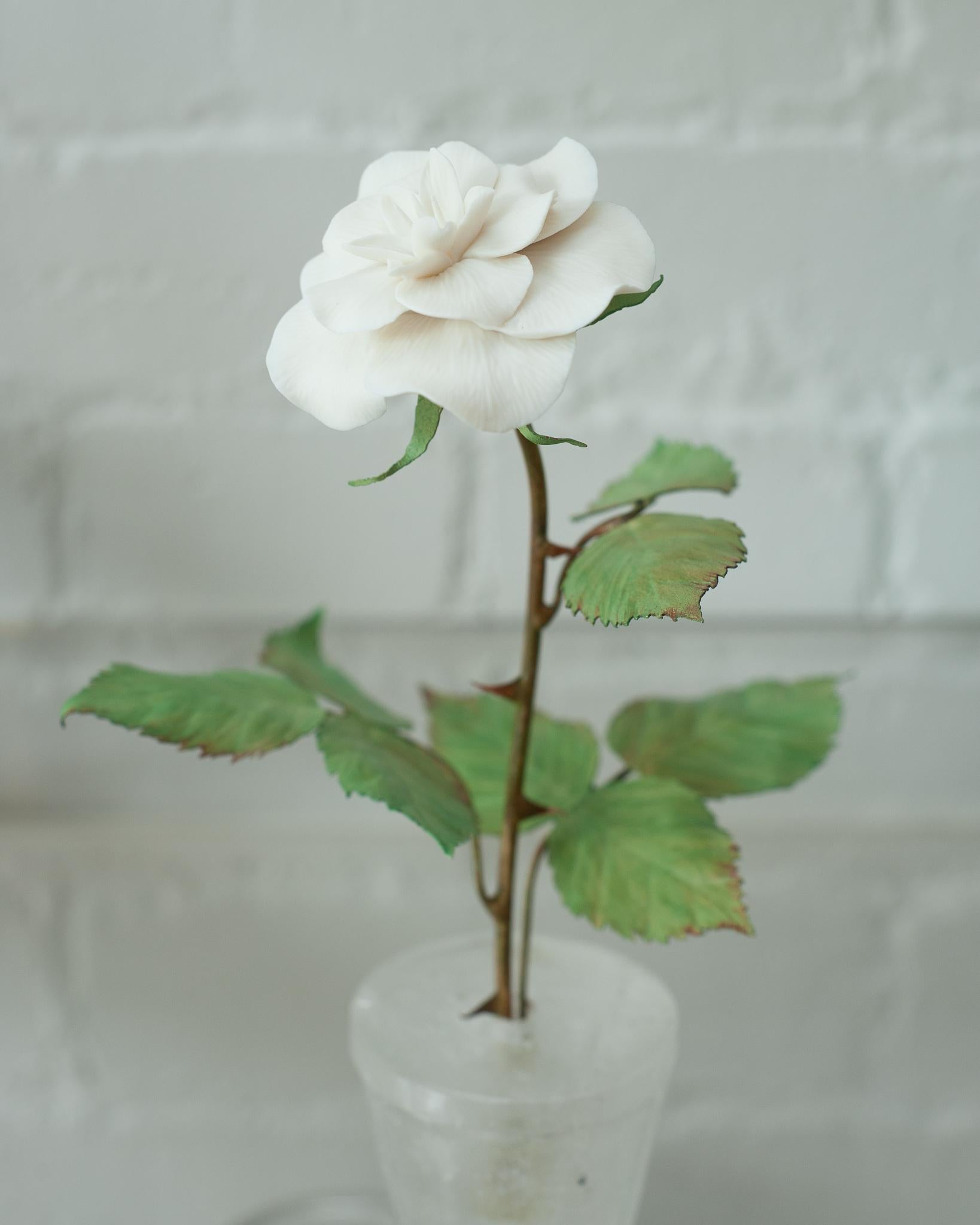 Verschönern Sie Ihren Tisch mit diesen zarten Porzellanblumen des französischen Künstlers Samuel Mazy. Dieser Rosenstrauch ist handgefertigt aus Biskuitporzellan mit bemalten Kupferblättern und -stängeln und steht in einem Bergkristalltopf. Eine