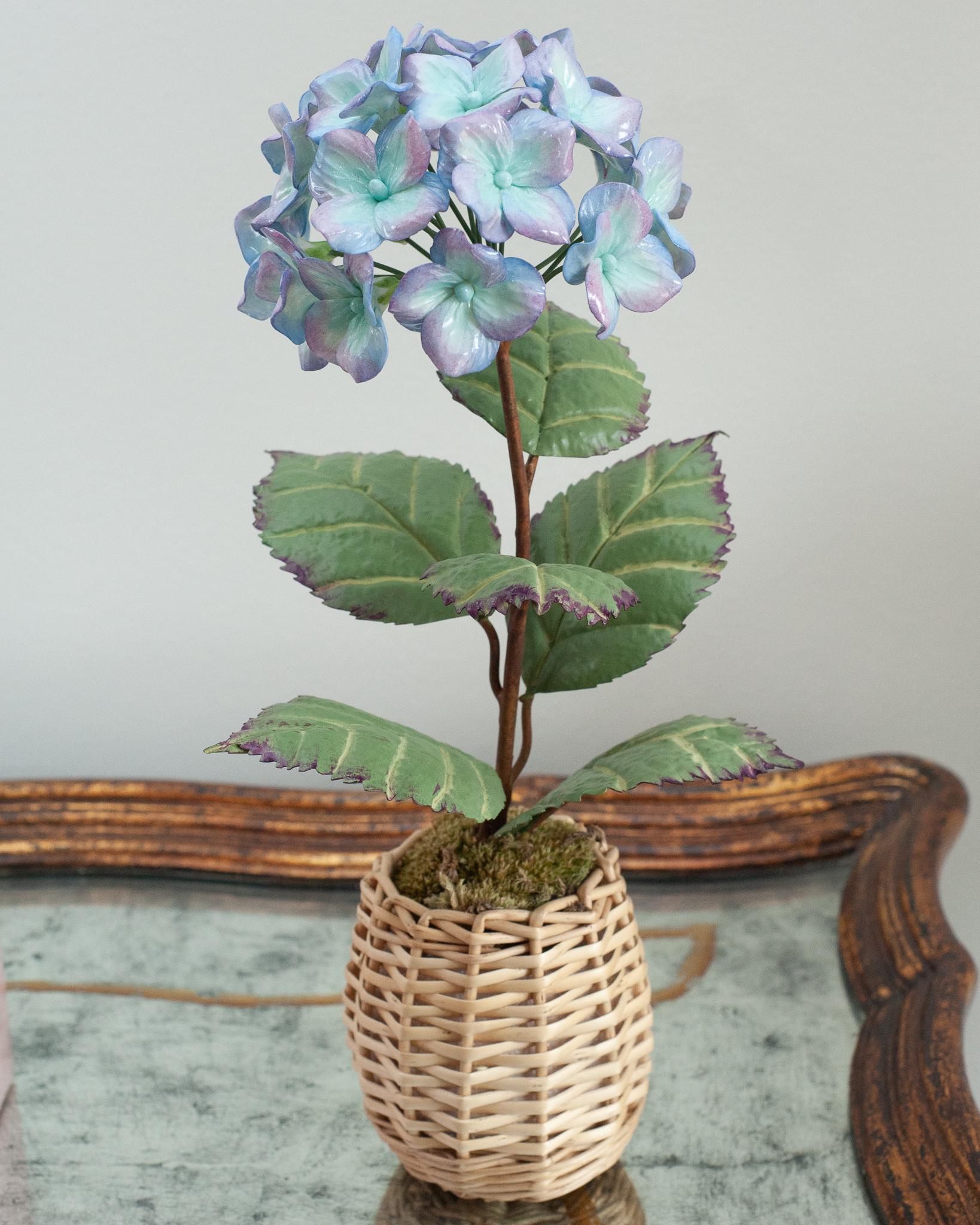 Verschönern Sie Ihren Tisch mit diesen zarten Porzellanblumen des französischen Künstlers Samuel Mazy. Diese lilafarbene und blaue Hortensie ist aus glasiertem Porzellan handgefertigt, mit handbemalten Kupferblättern und -stängeln, und steht in