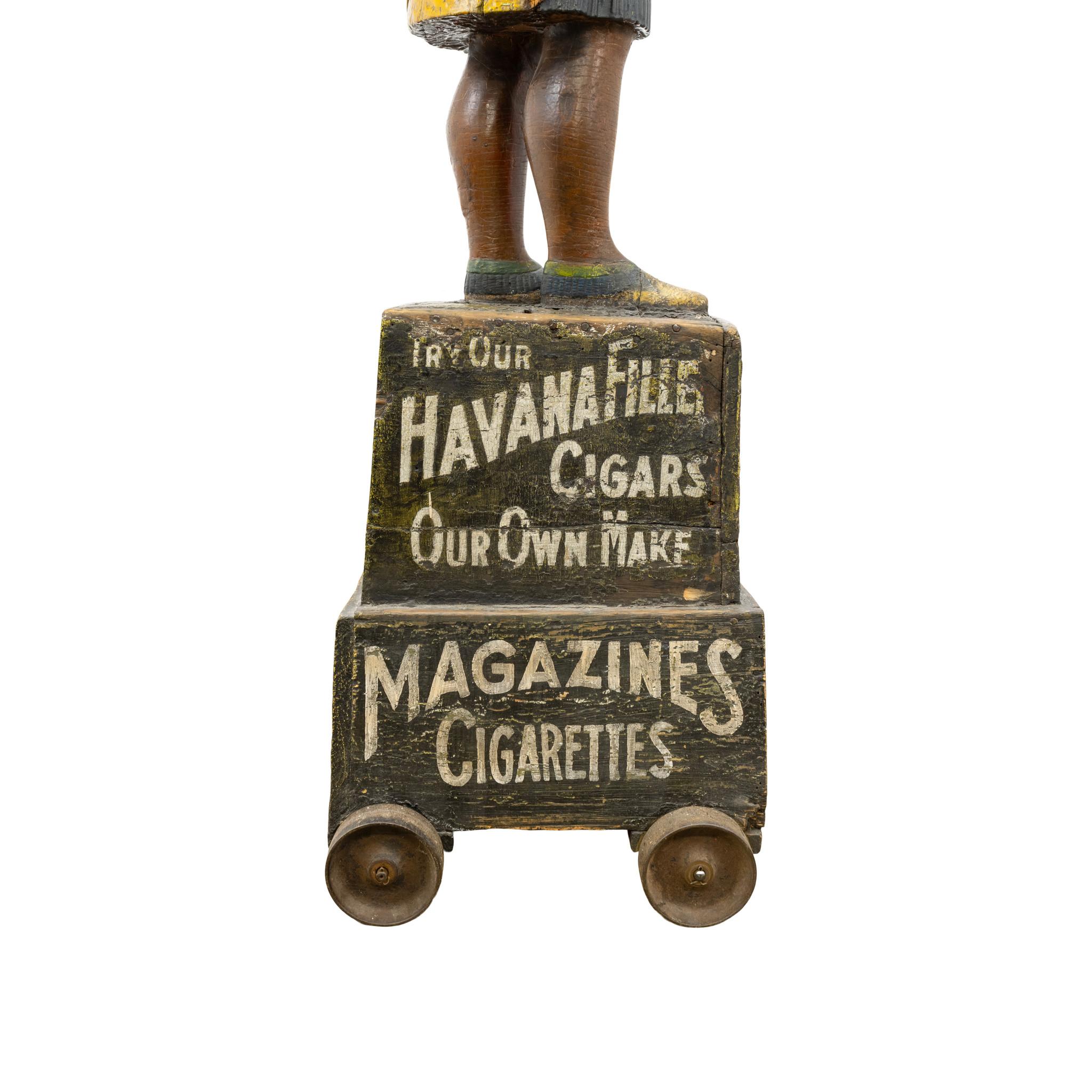 Tobacciana trade sign carved by Samuel Robb, New York, Circa 1885. Figure holds a knife and bundle of cigars with tobacco boxes. Retains original base. Total height from floor is 74