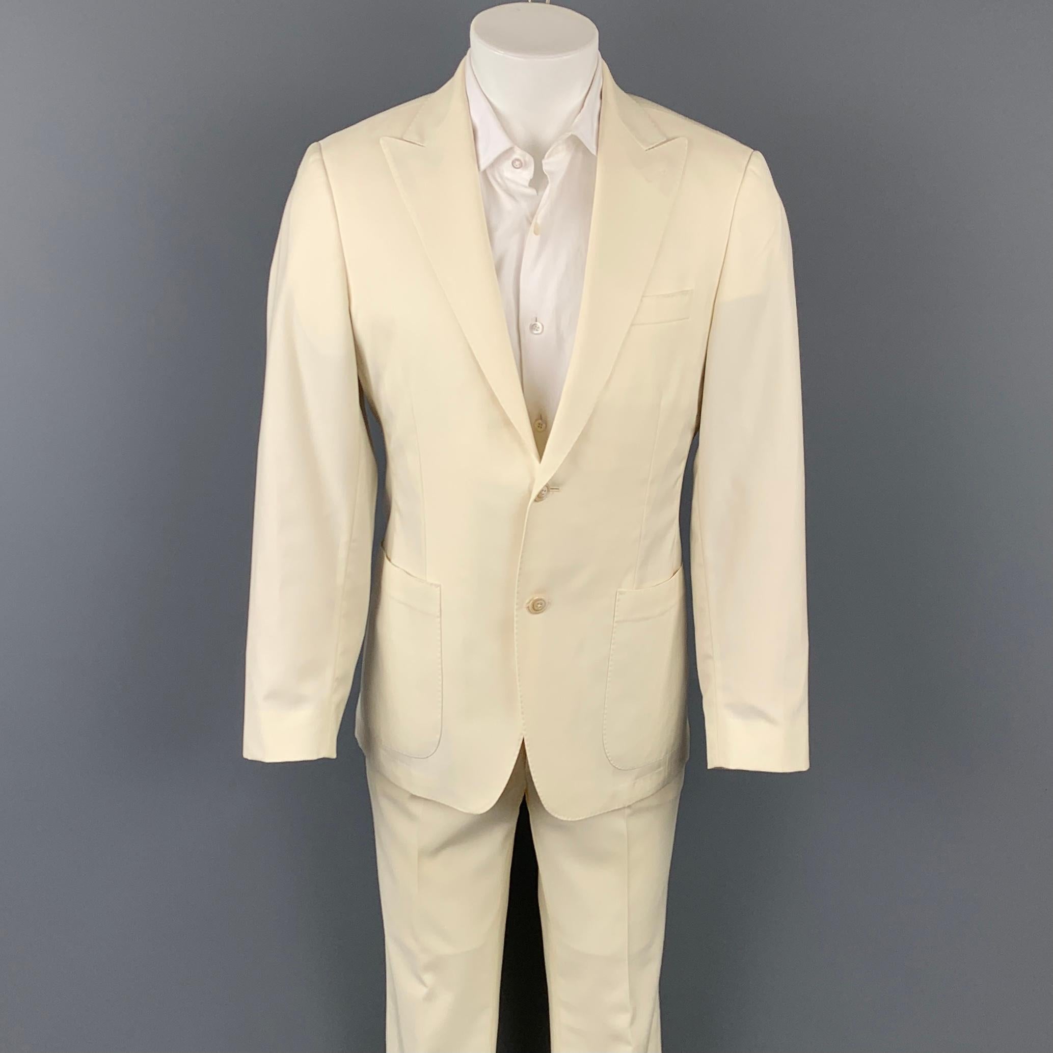 SAMUELSOHN for WILKES BASHFORD suit comes in a cream wool with a half liner and includes a single breasted, two button sport coat with a peak lapel and matching flat front trousers.

Very Good Pre-Owned Condition.
Marked: