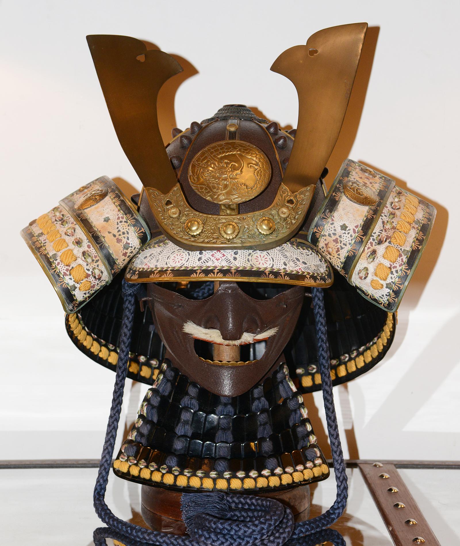 Samurai Yoroi Kabuto Helmet with wrought Iron
and with details in solid brass. With fabrics and prints 
on fabric pieces, mustache with real bear hair and with 
wrought iron mask, with solid wooden base.