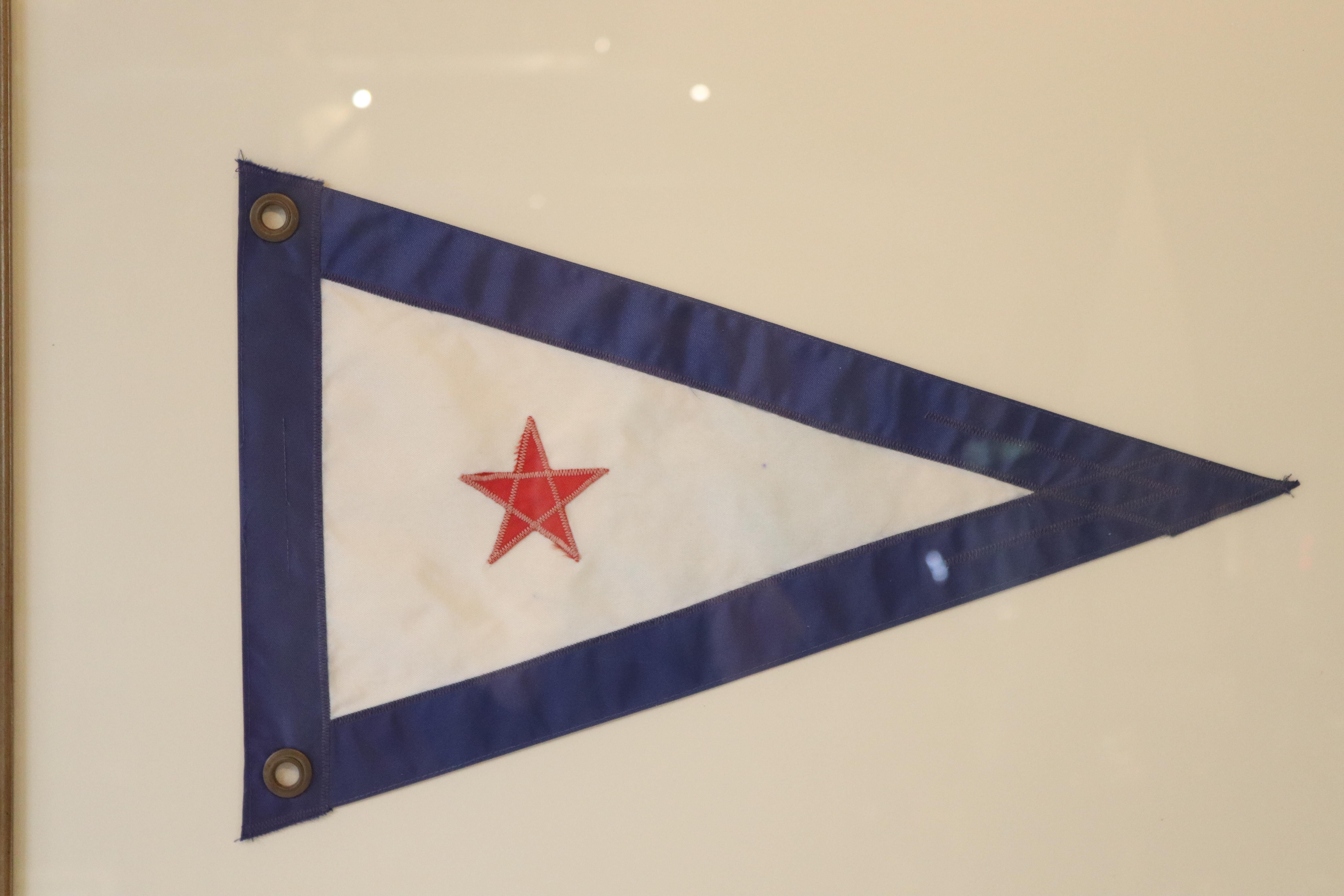 Nautical flag from the San Diego Yacht club. Red star on a white field with blue border. matted and framed. Measures: 24