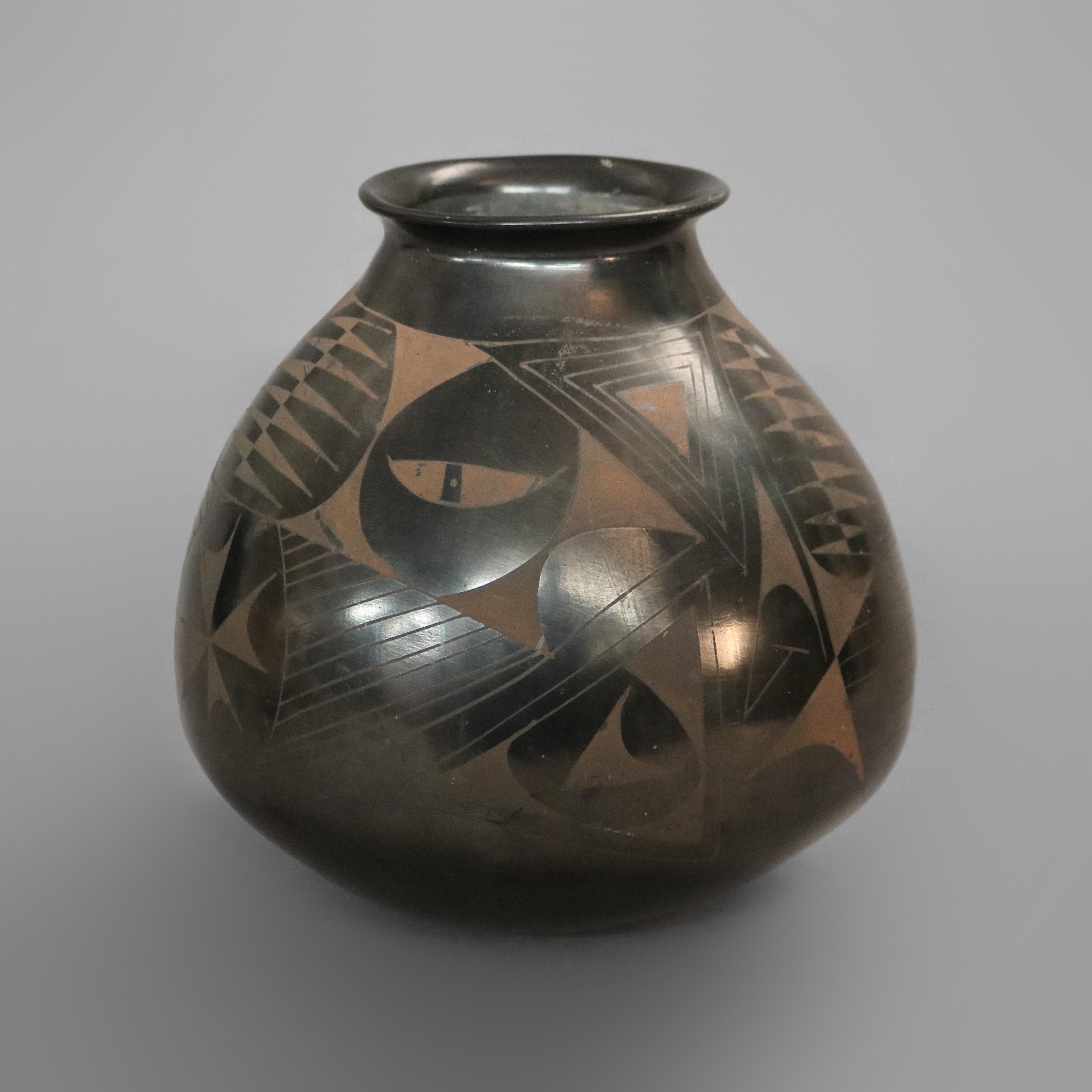 A southwestern Native American art pottery vase in the manner of Maria Martinez of San Ildefonso Pueblo by Juan L’été offers black on black with stylized foliate design throughout, artist signed, circa 1930

Measures - 10.25''H x 9.75''W x 9.75''D.