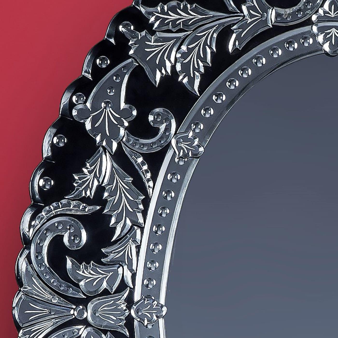 Luxurious oval mirror in 19th-century French style Murano glass made by Fratelli Tosi based on Fratelli Barbini design. The band that embraces the central mirror is engraved with a floral motif, the whole external frame is a succession of curls