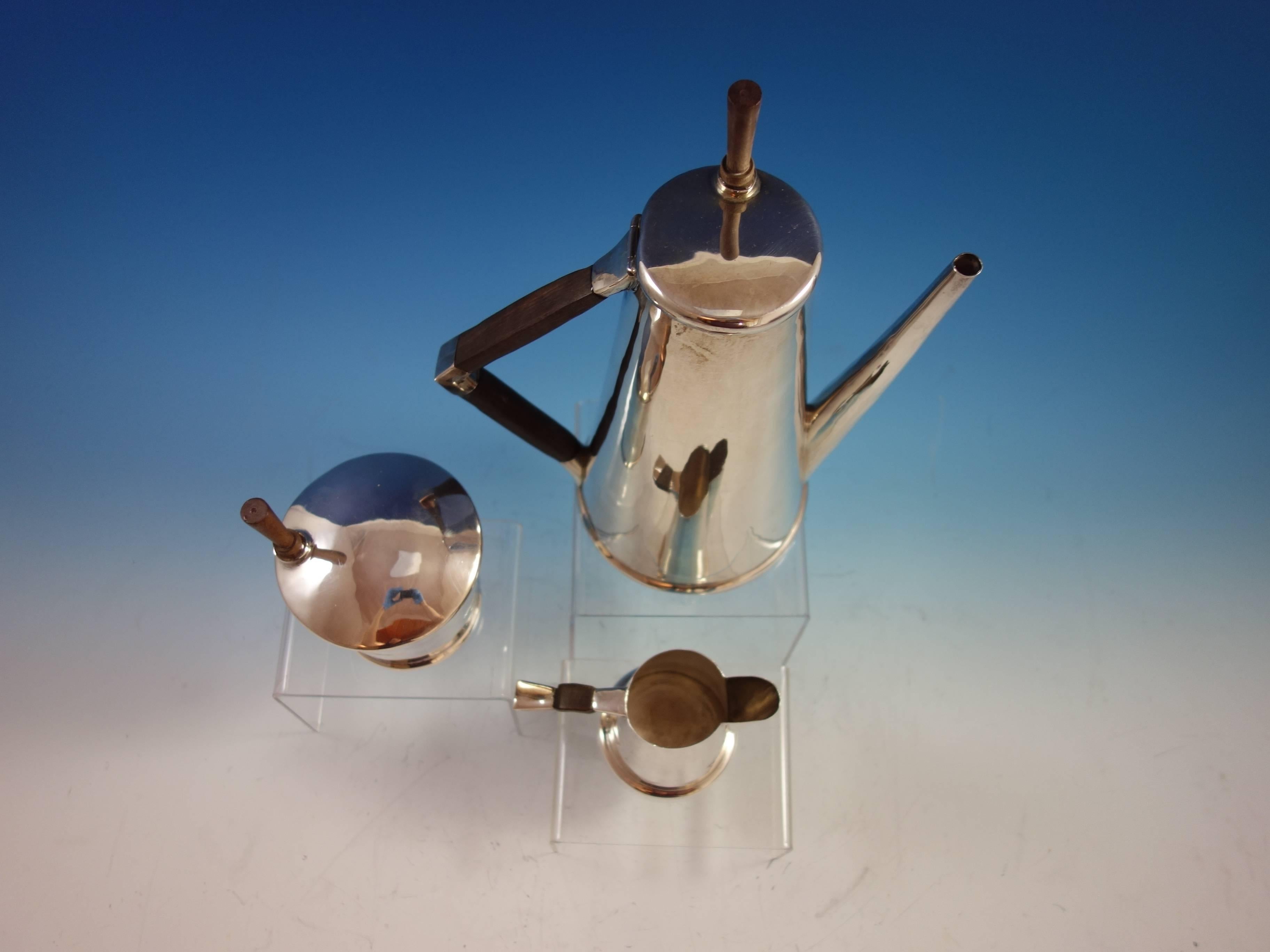 Modernist Mexican sterling silver three-piece coffee set made by Sanborns with rosewood accents. The pieces are marked with #7015. The set includes:

One coffee pot: Weighs 25.7 ozt., and measures 11 1/4