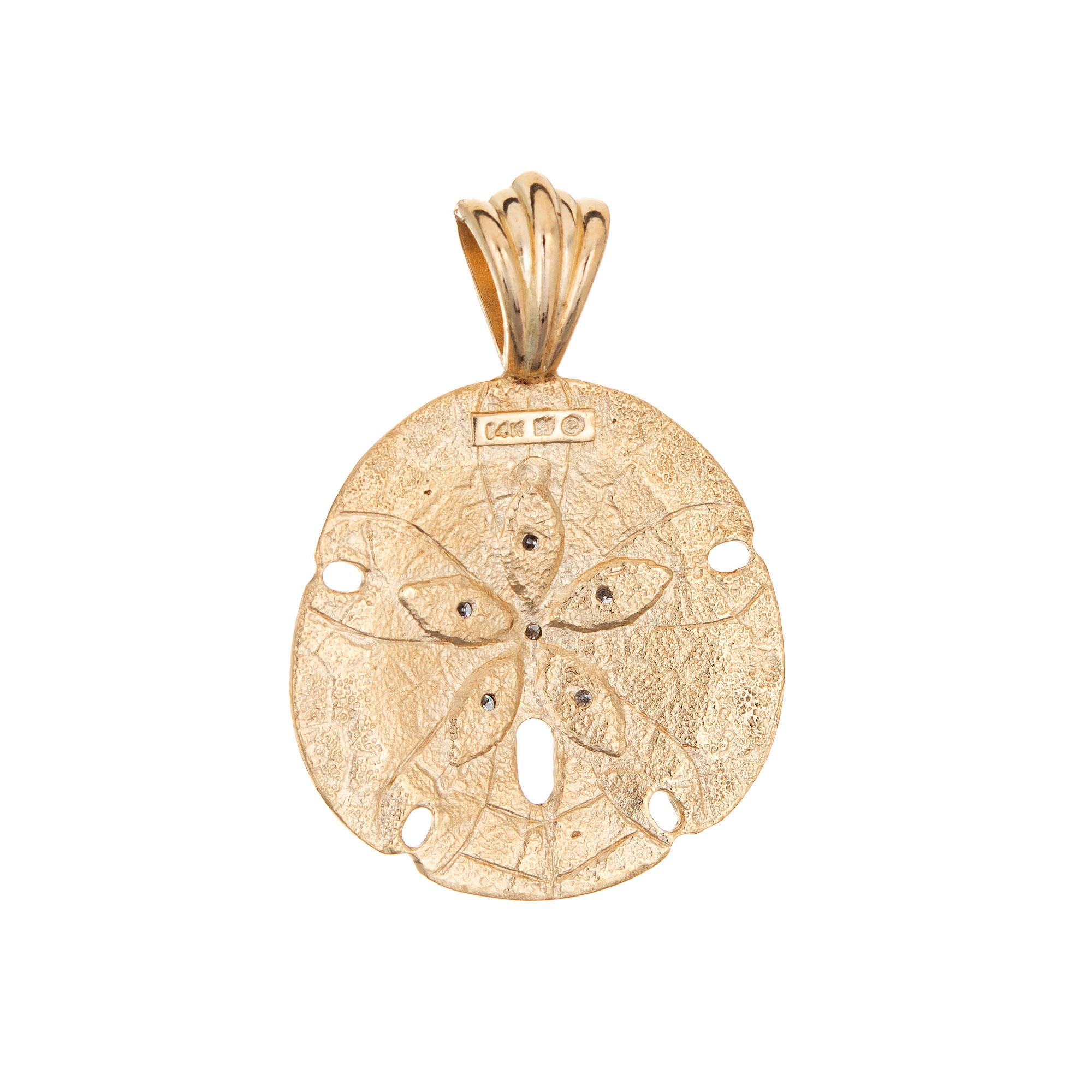 Finely detailed Sand Dollar pendant crafted in 14k yellow gold.  

Five diamonds total an estimated 0.05 carats (estimated at H-I color and SI1-2 clarity). The sand dollar features a textured finish with diamonds set to the center. The piece can be