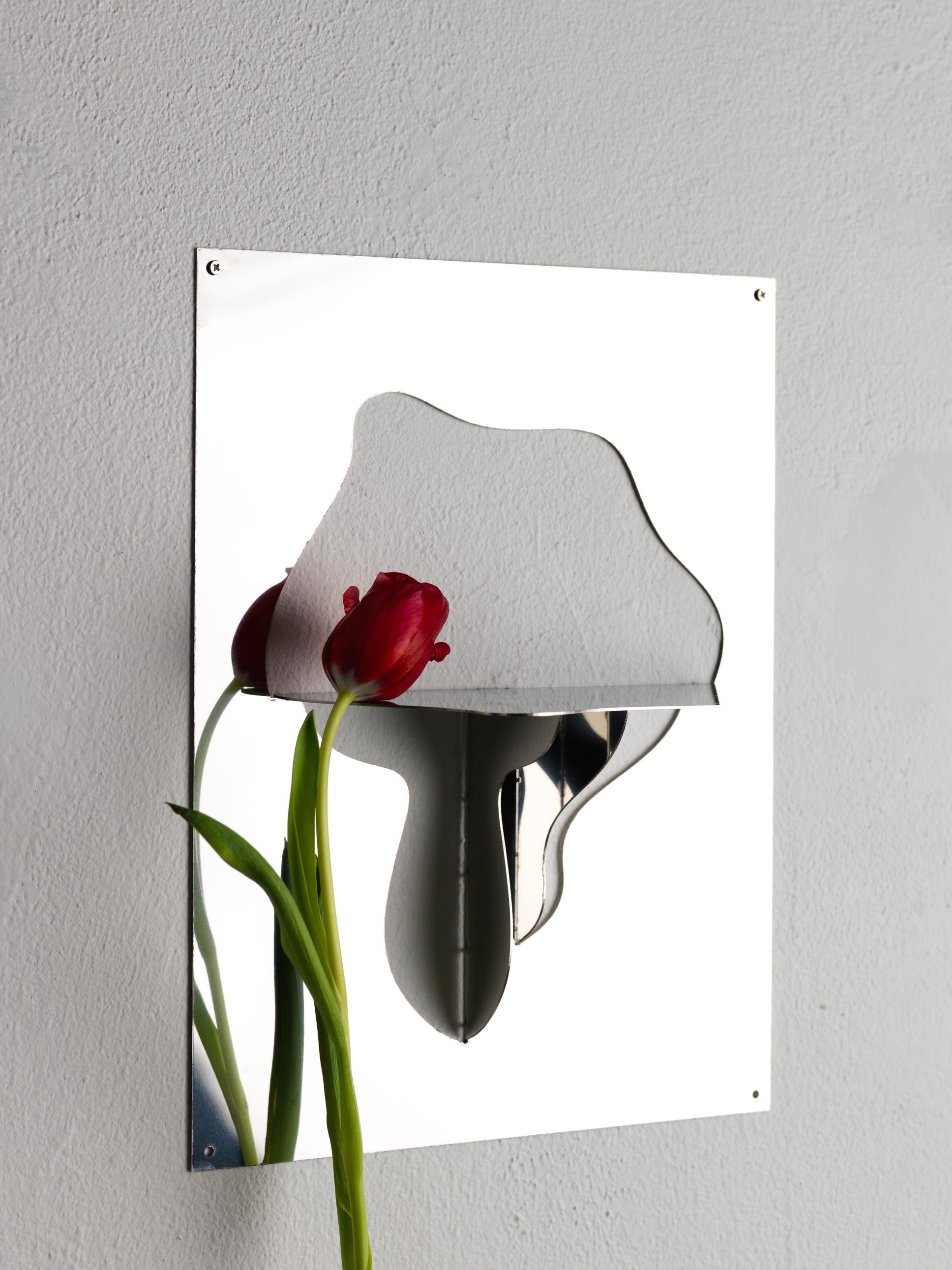 Made locally in Scania, south of Sweden. It is an item made in mirrored steel. It can easily get scratches and needs to be treated with care. The designer bends the mirrored shelf by hand in her studio from Malmö and it is signed with number. These