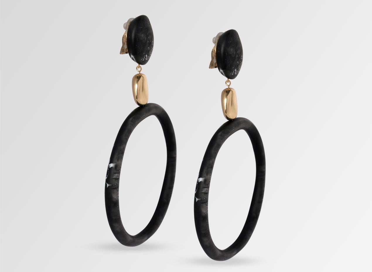 Clip-on (nickel-free) resin hoop earrings with brass detail bead. These earrings are featured in our Classic colour, Black Marble. 

Dinosaur Designs resin products are hand made in Sydney, Australia. Each piece is unique and we cannot guarantee you