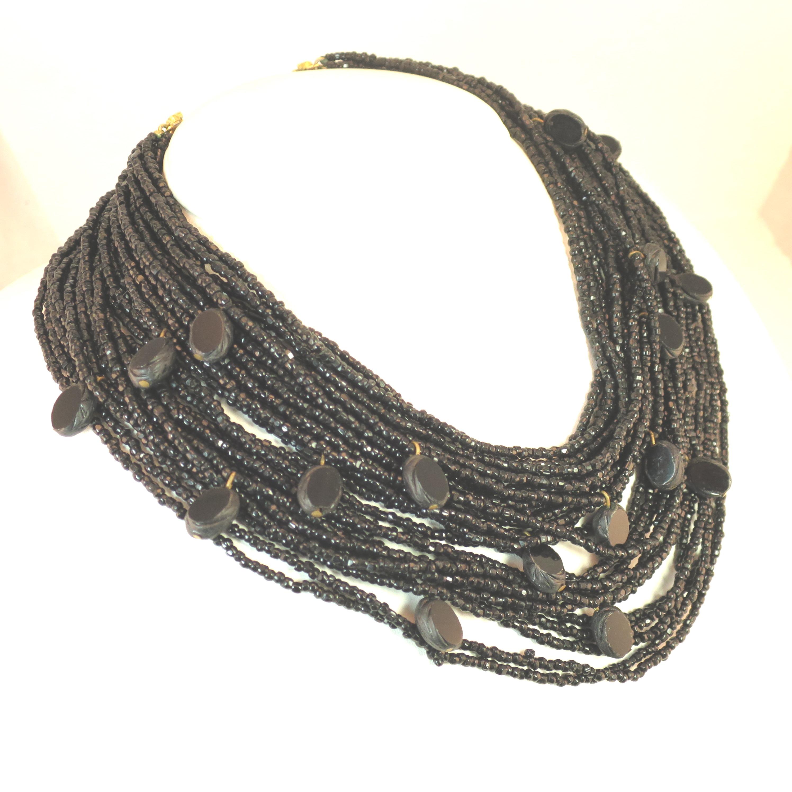 Offered here is a Mid-Century Sandor draping multi-strand beaded necklace and matching clip-back earrings of French jet glass from the 1940s. A profusion (27 to be exact) of graduated strands of tiny black french jet glass seed beads are embellished