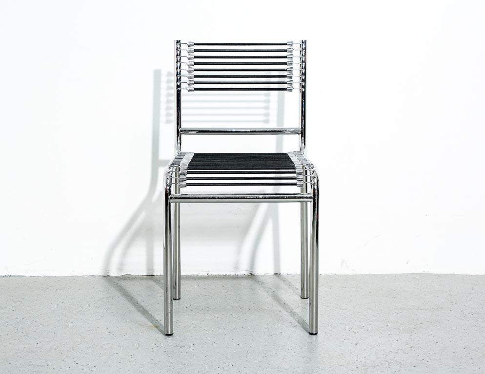 'Sandows' dining chairs designed by René Herbst. Chrome tubular frame with bungee seat and back. Designed in 1928, this piece is considered an early modernist masterpiece well ahead of its time. Multiple available. Measure: 17.5