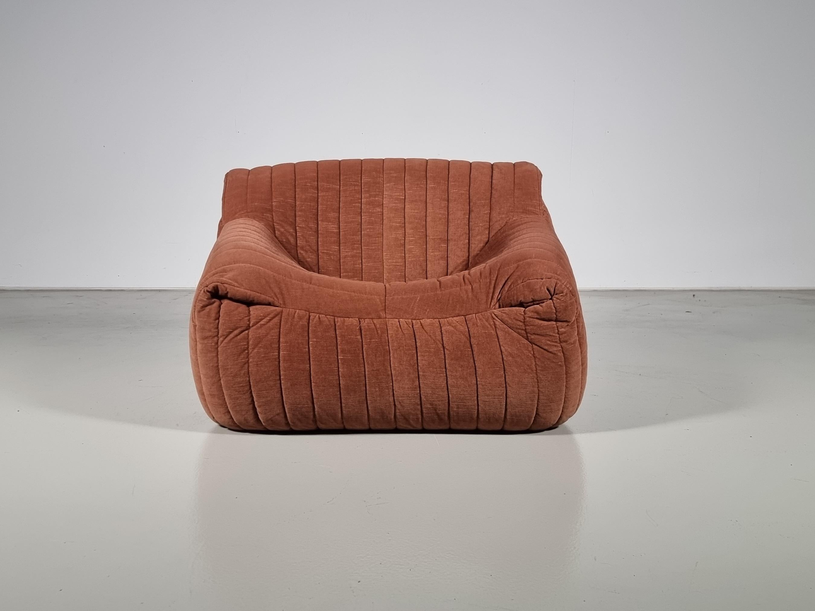 The Sandra lounge chair was designed by Annie Hiéronimus for Cinna after she joined the Roset Bureau d'Etudes in 1976.

Constructed fully from foam, the chair has a solid form. Upholstered in its original rusty/brown fabric. It's extremely