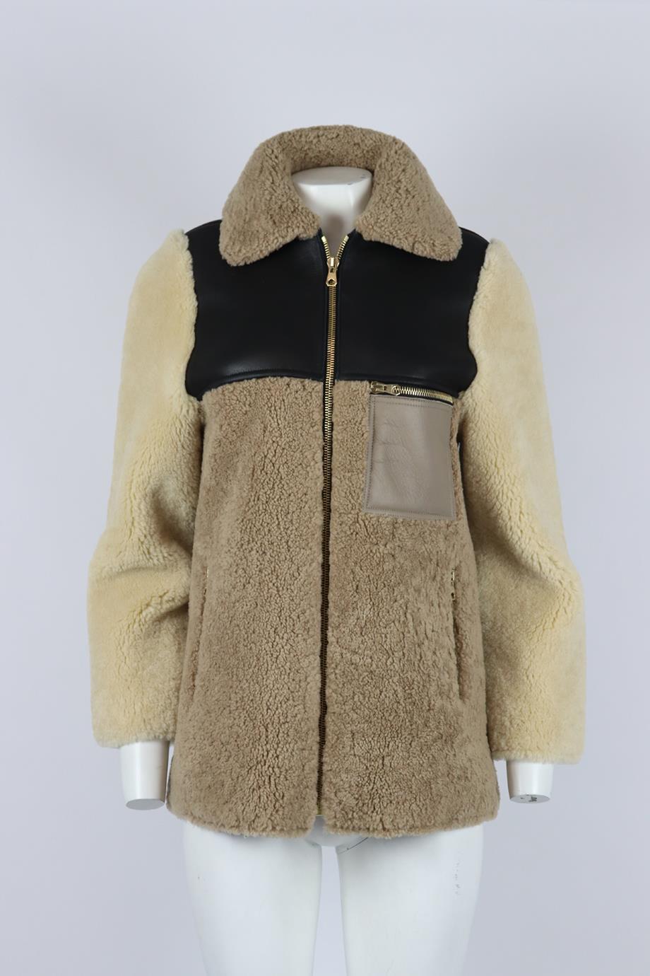 Veste en shearling à panneaux de cuir Sandro. Beige, marron et noir. Manches longues, col ras du cou. Fermeture à glissière sur le devant. 100% Shearling ; doublure du corps : 100% viscose ; doublure des poches : 100% coton. Taille : XSmall (UK 6,