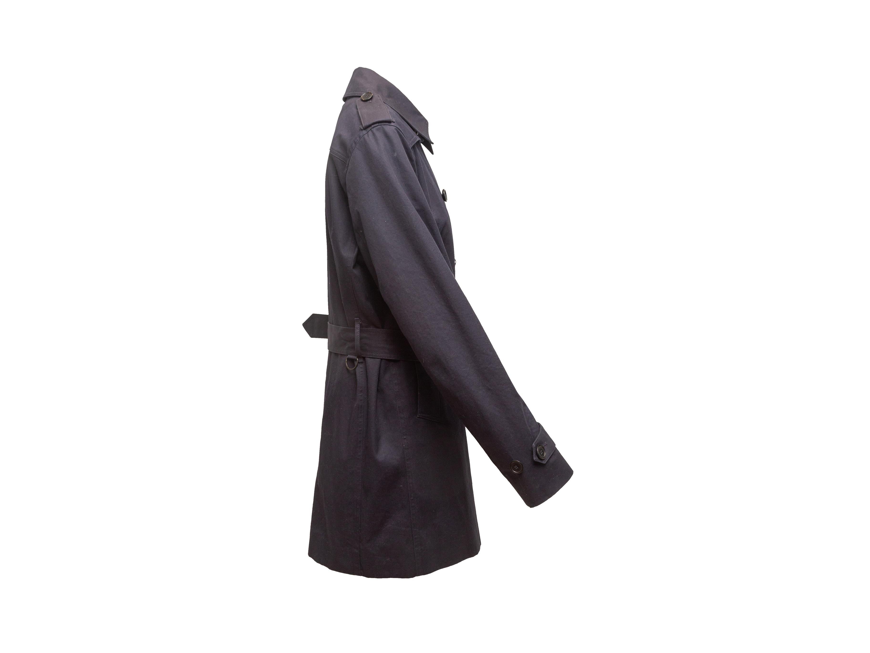 Product details: Navy double-breasted long trench coat by Sandro. Pointed collar. Dual hip pockets. Belt at waist. Button closures at front. 37