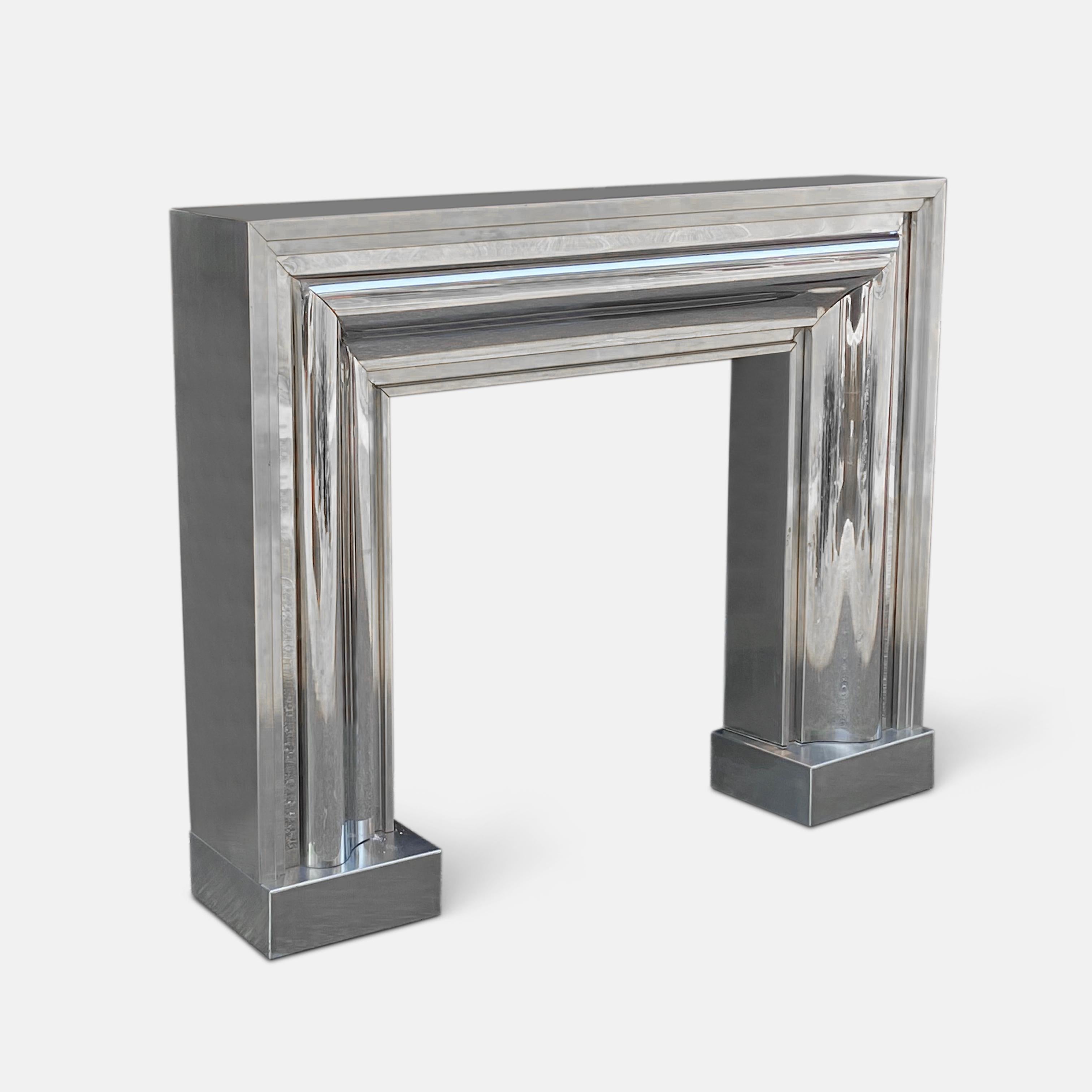 Fireplace surround by Sandro Petti for Maison Jansen circa 1970. 
A magnificent surround of stepped and curved form in chrome and steel raised on two low steel plinths.
