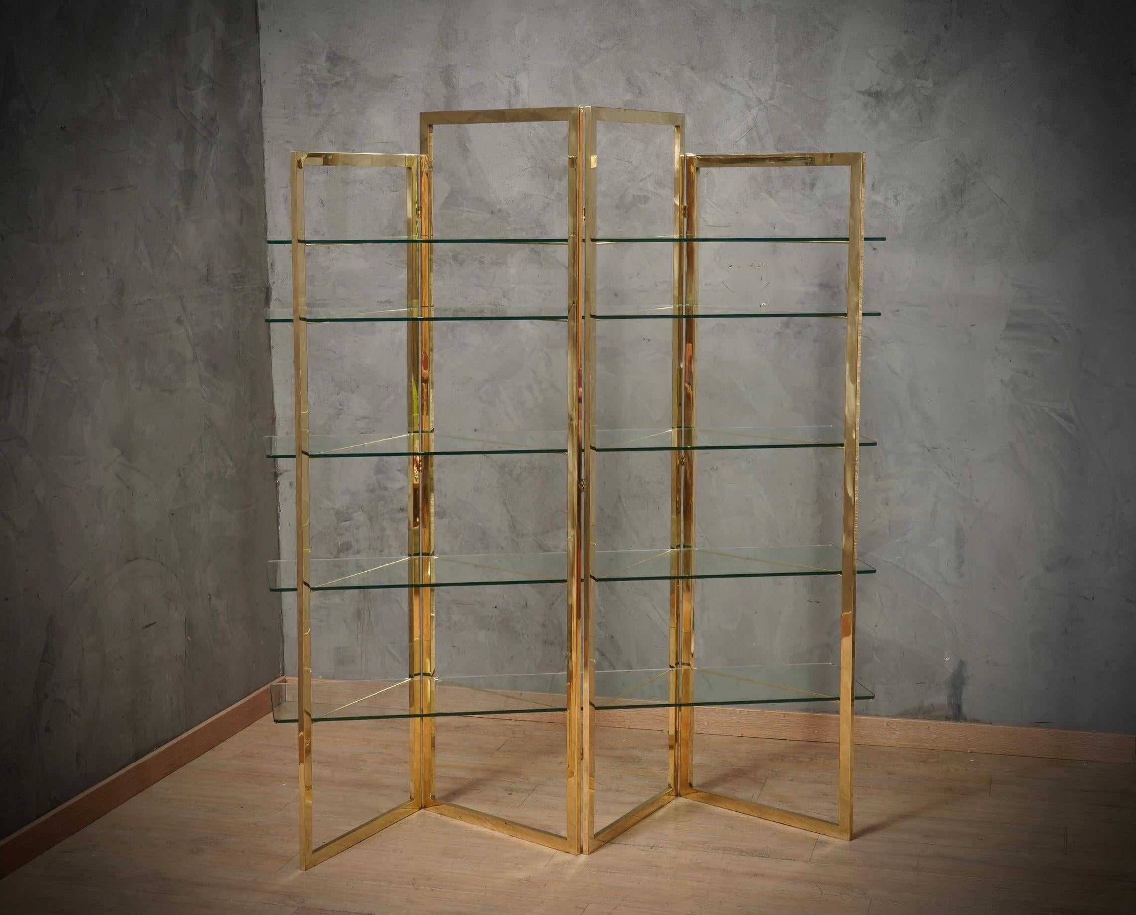 Stunning brass accordion movement bookcase with cut glass shelves. Simple and linear design for Sandro Petti.

The bookcase is composed of a simple and linear brass structure, which opens like an accordion. In the central part of the brass squares,