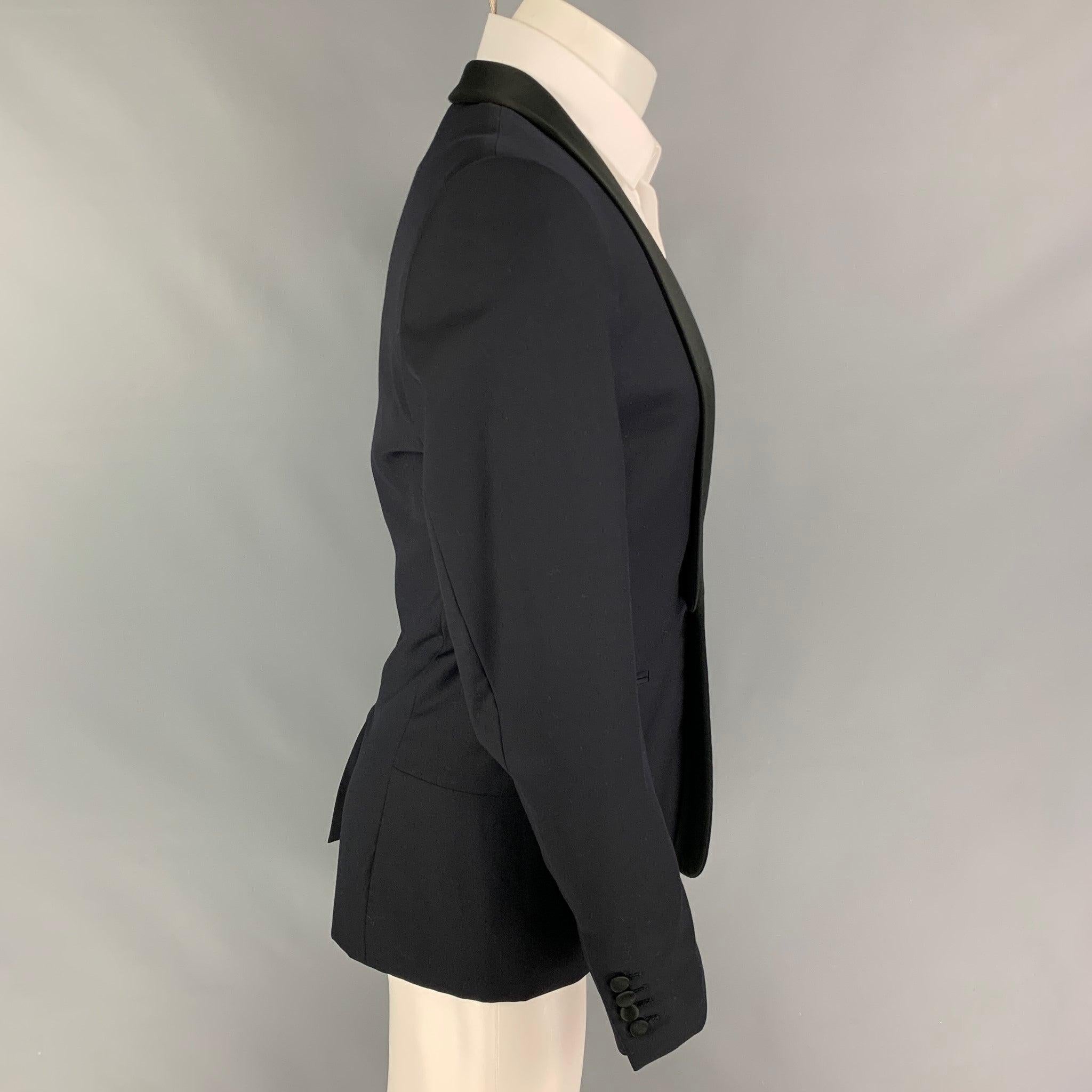 SANDRO sport coat comes in a black wool with a full liner featuring a shawl collar, slit pockets, single back vent, and a single button closure.
Very Good
Pre-Owned Condition. 

Marked:   48 

Measurements: 
 
Shoulder: 17.5 inches  Chest: 38 inches
