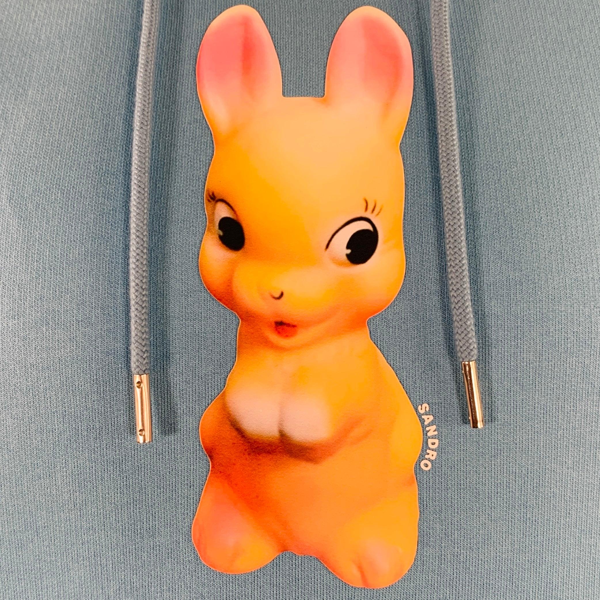 SANDRO sweatshirt
in a blue cotton jersey featuring a hooded style, orange bunny print, and kangaroo pocket. Made in Portugal.Very Good Pre-Owned Condition. Minor mark on cuff. 

Marked:   size not marked 

Measurements: 
 
Shoulder: 19.5 inches