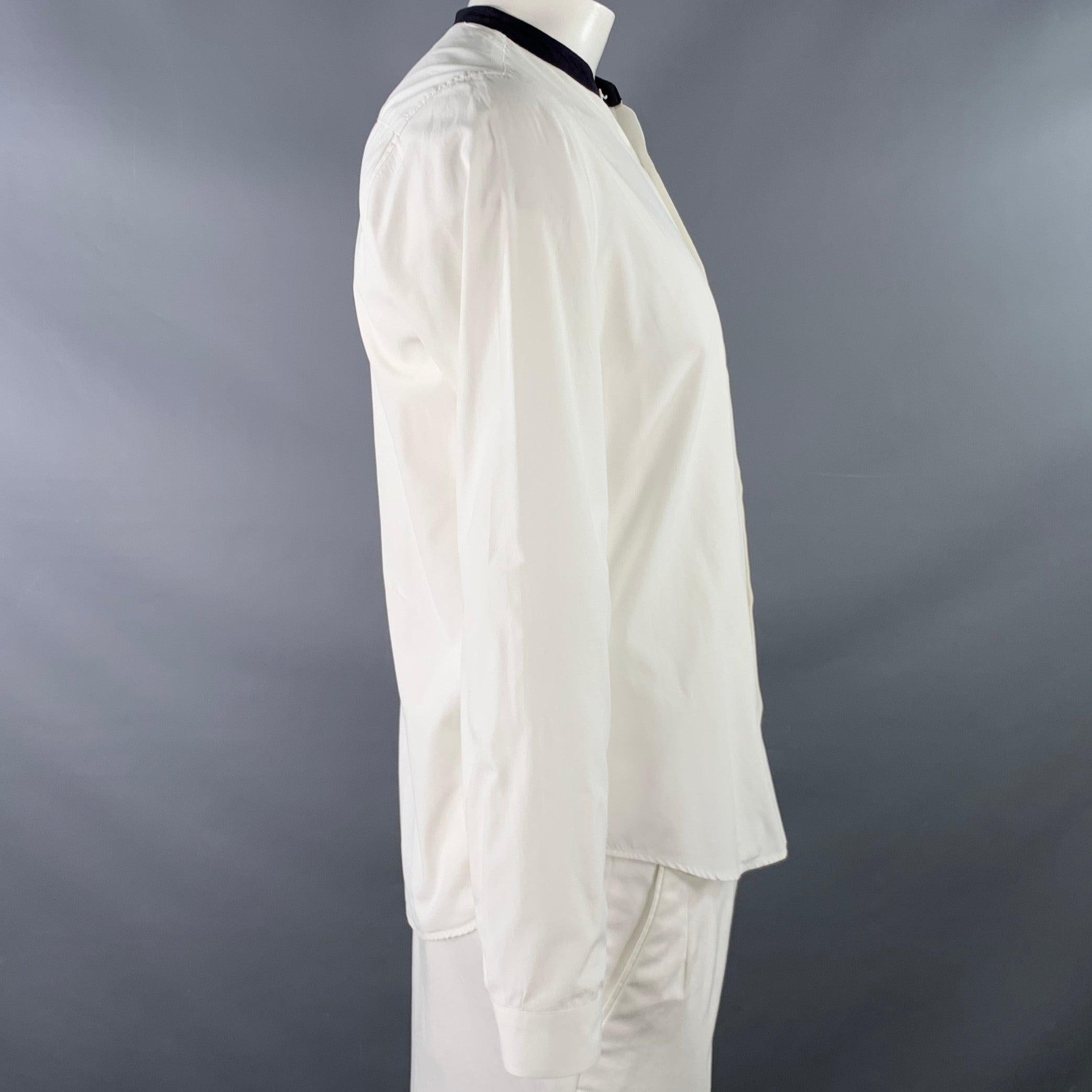 SANDRO long sleeve shirt
in a white cotton woven fabric featuring a collarless style, black contrasting trim, and button closure.Very Good Pre-Owned Condition. Minor marks on cuff. 

Marked:   L 

Measurements: 
 
Shoulder: 16.5 inches Chest: 42