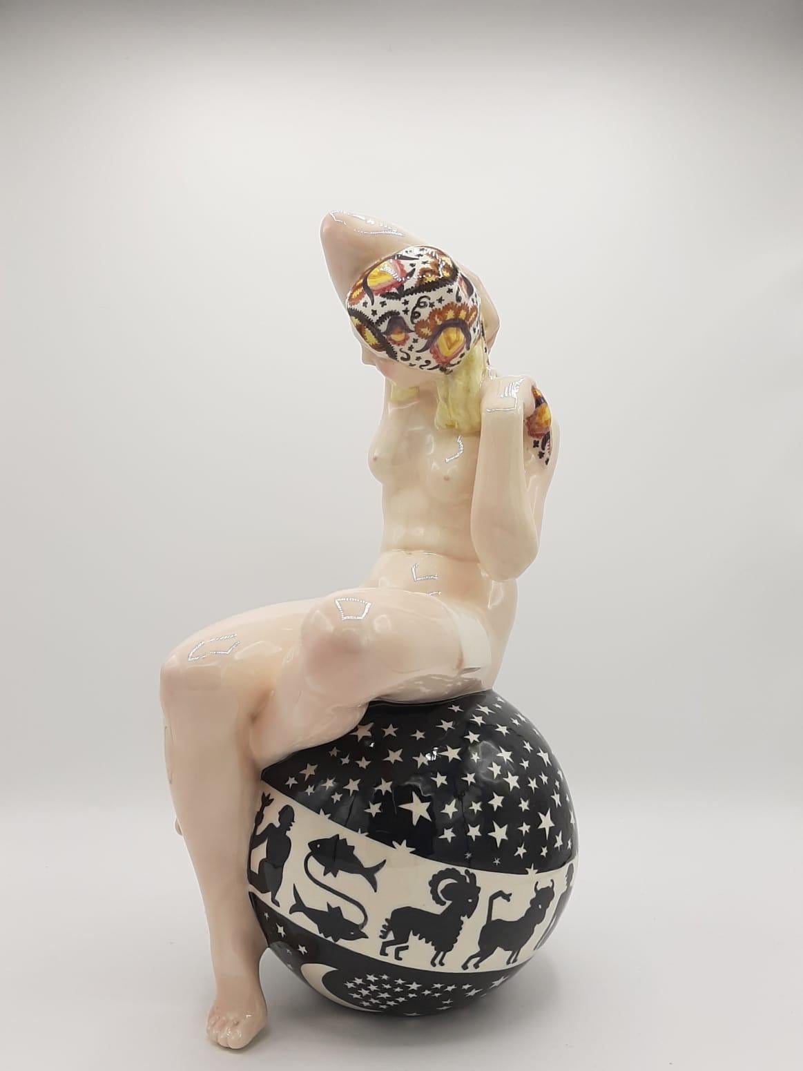 Sandro Vacchetti (Italian, 1889-1976) for Essevi
'Il mondo e il suo castigo': An Earthenware Figure, circa 1930s
polychrome, and modelled as a nude blonde female wearing a headscarf and seated on a ball decorated with stars and signs of the