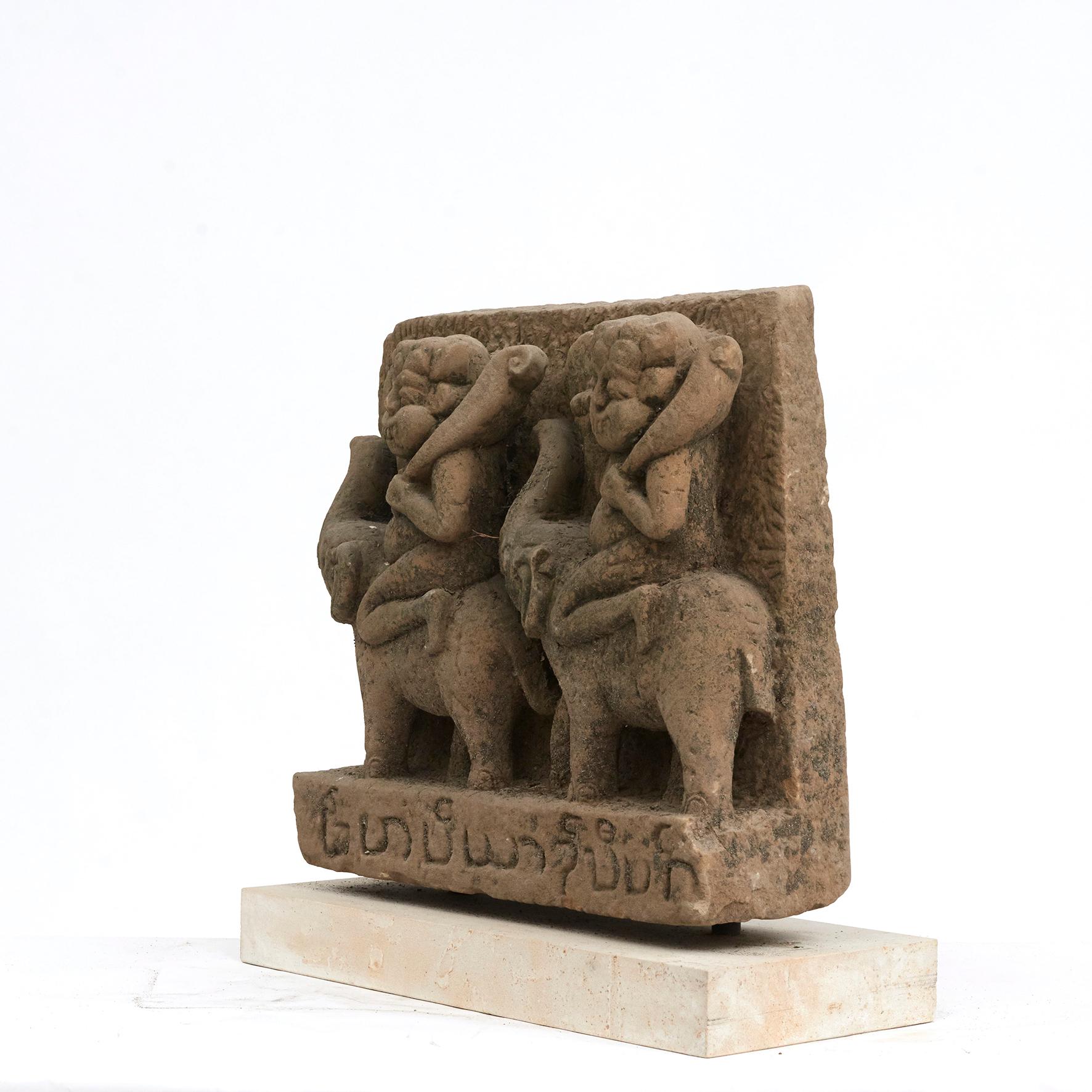 500-600 year old sandstone carving. The sculpture is depicting 'Two demons riding on elephants'. 
From Buddha pagoda / temple in Arakan, Burma, 1400-1500.

Untouched and in original condition with great patina. Mounted on light sandstone