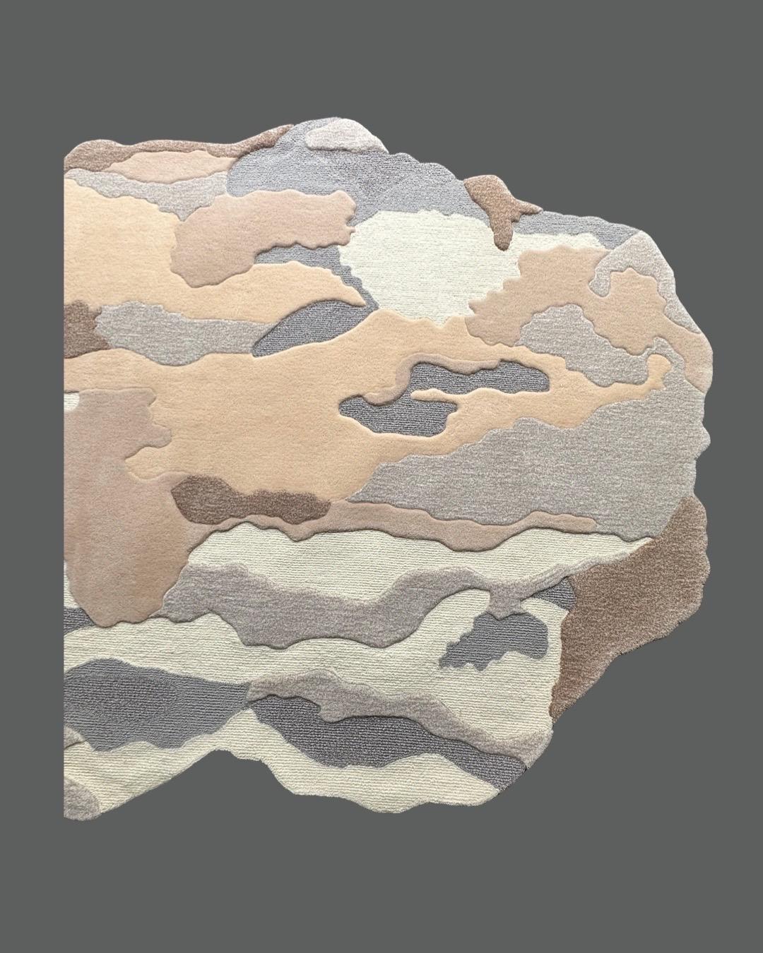 Inspiré par l'érosion naturelle des falaises de grès et des paysages désertiques, ce tapis présente des motifs fluides et organiques dans des tons chauds de beige, de gris doux et de terre. Les textures stratifiées imitent les courbes douces et la