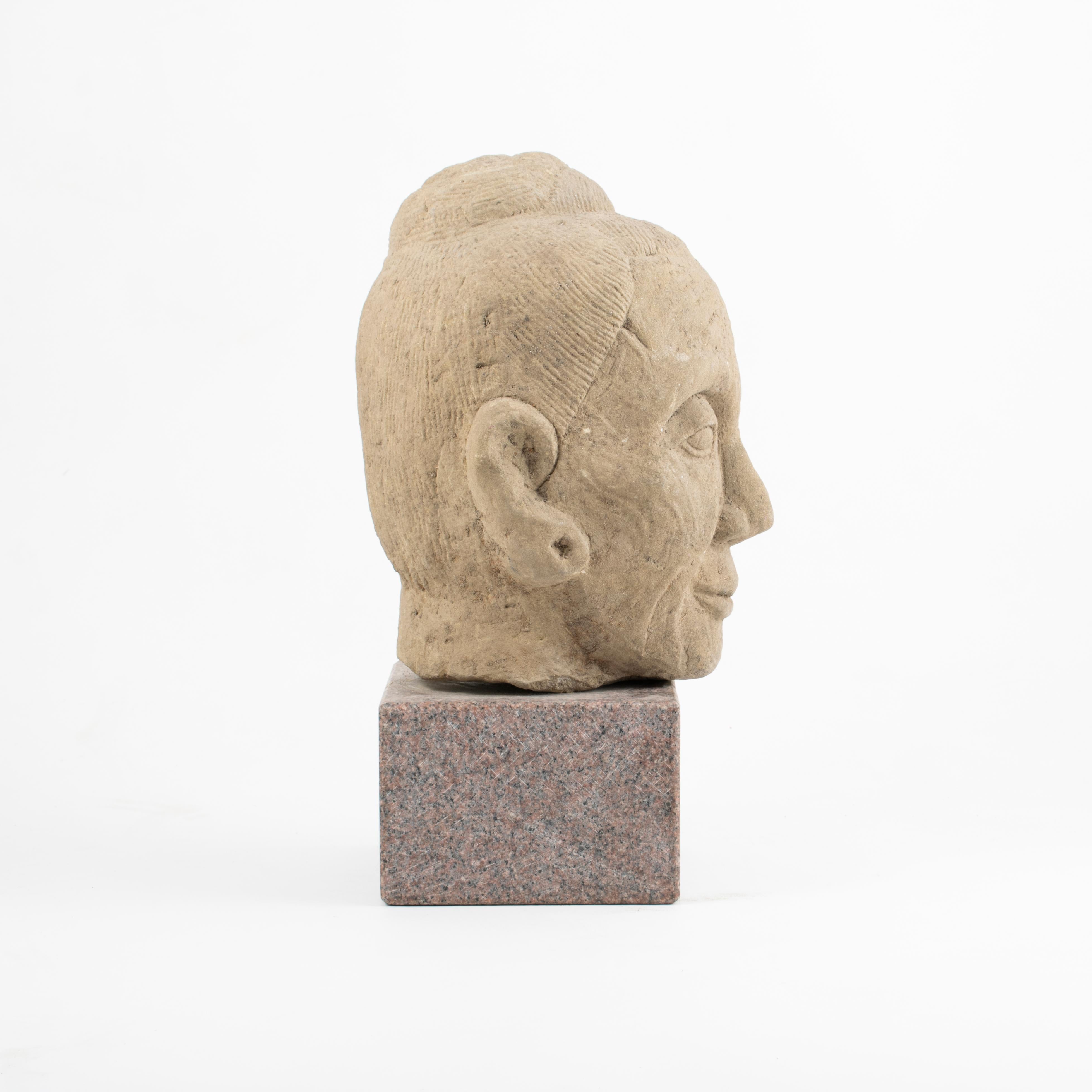 16-17. Jahrhundert handgeschnitzter Sandsteinkopf eines Lohan.
Gekonnte Ausführung, die das Gesicht mit kräftiger Modellierung und harmonischem Ausdruck hervorhebt.
In originalem und unberührtem Zustand. Montiert auf einem späteren
