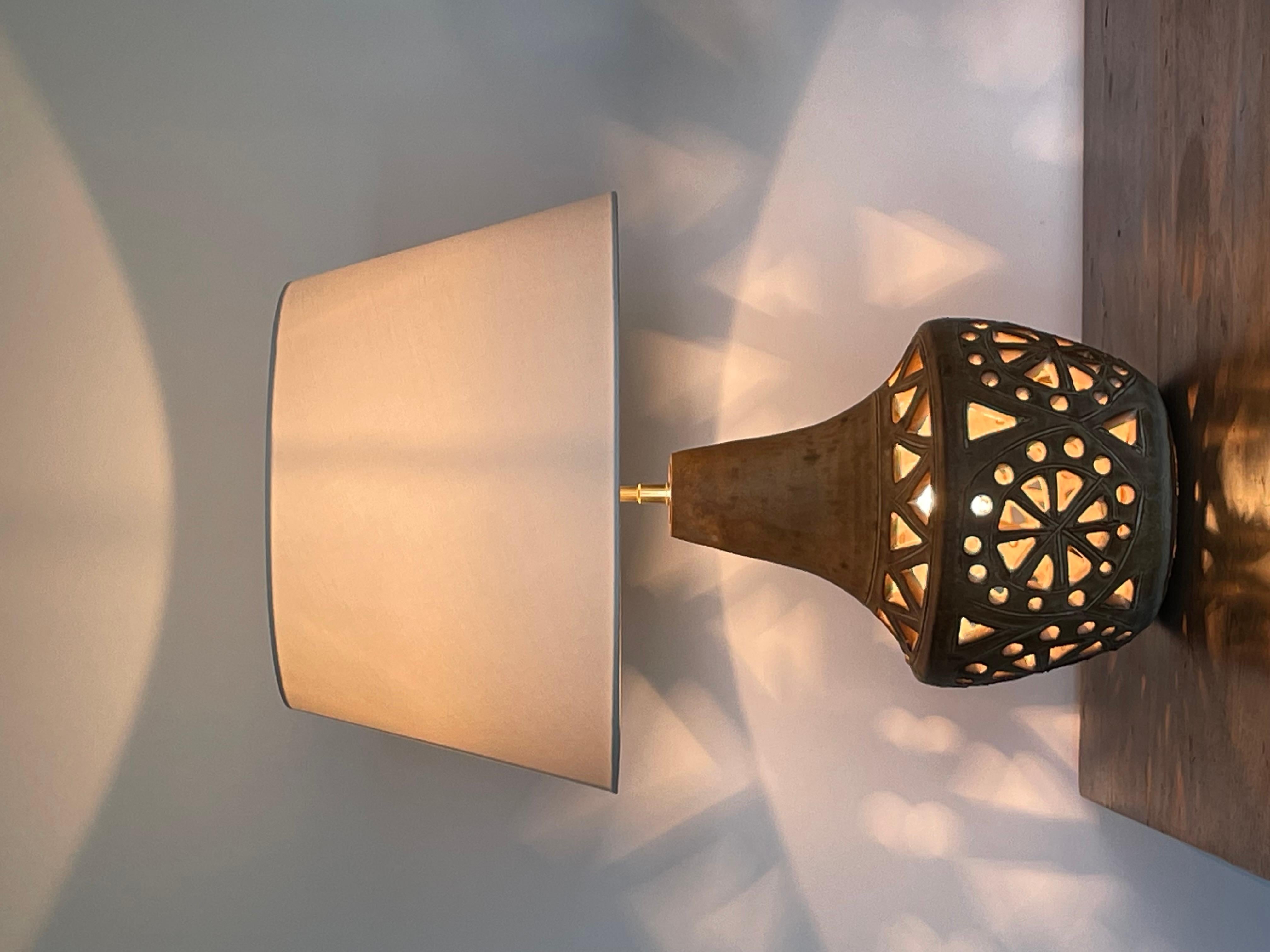 Openwork ceramic table lamp signed agnès escala and dating from the 1950s-1960s. The electrical assembly has been overhauled and the lampshade is new. Artist's signature on the base of the lamp base.