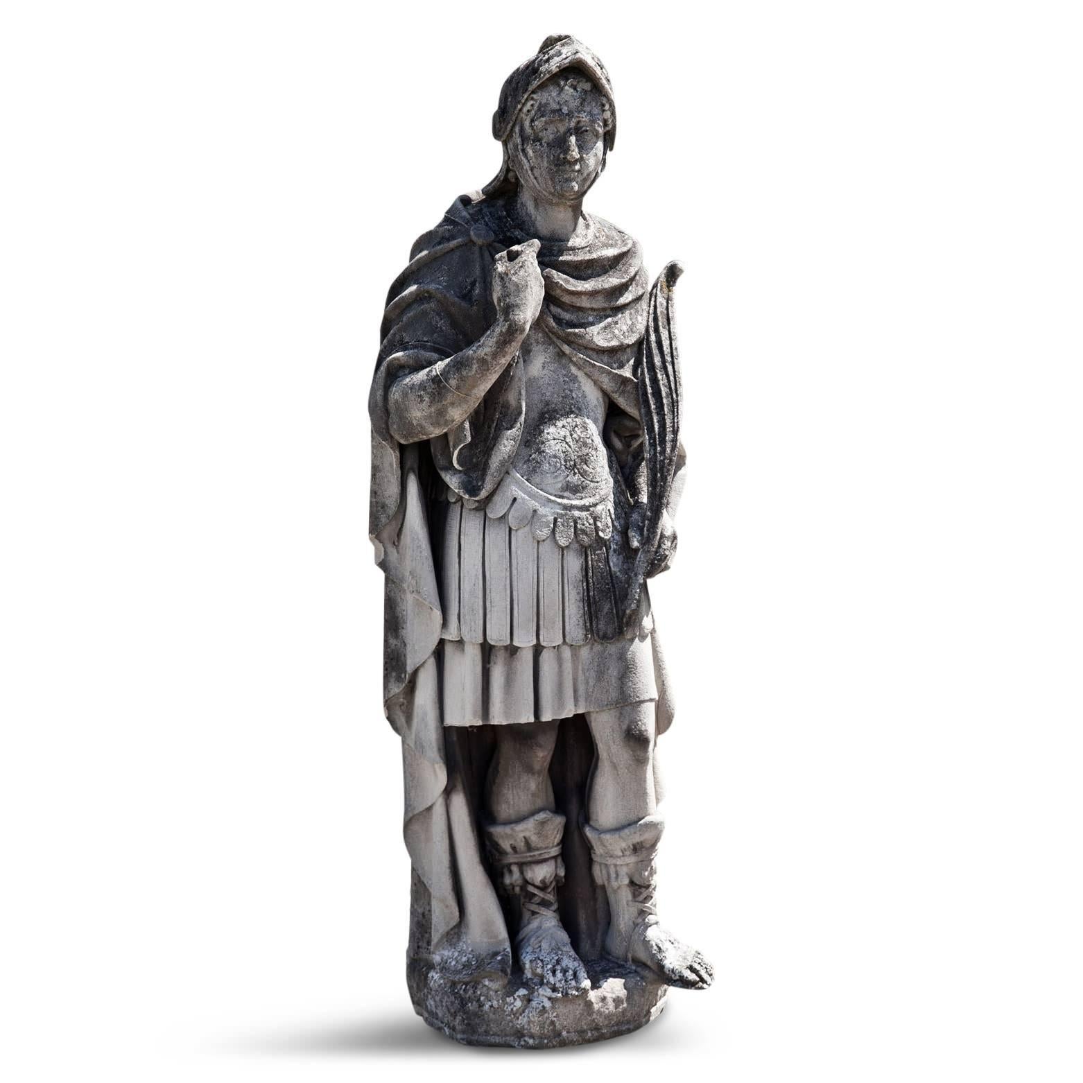 Lifesize helmed soldier in Roman-style armour with a long feather in his hand and a long cape draped over his shoulders. Very beautiful natural patina.
