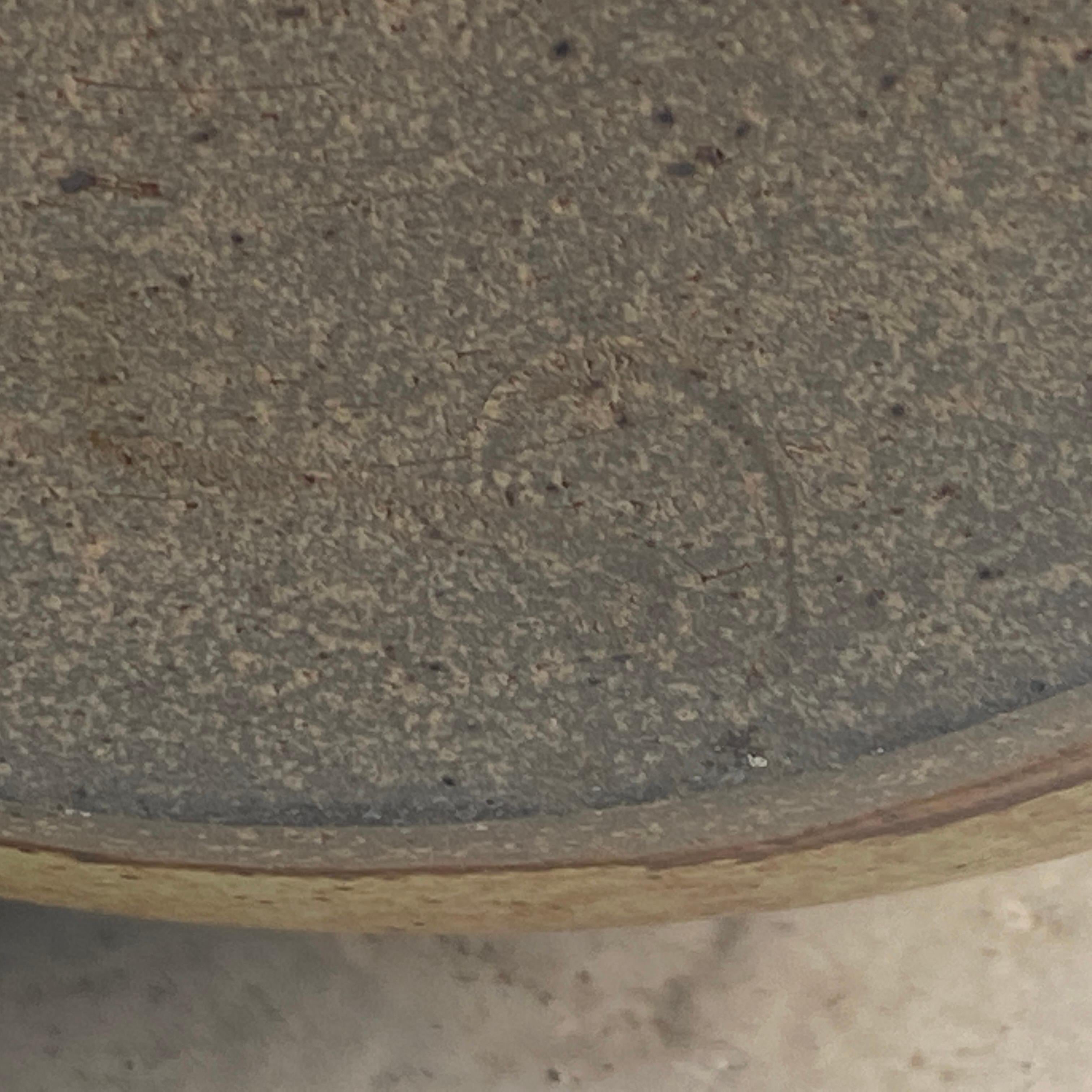 This table is in sandstone. It has been made around 1970, in France. The color is gray and brown.