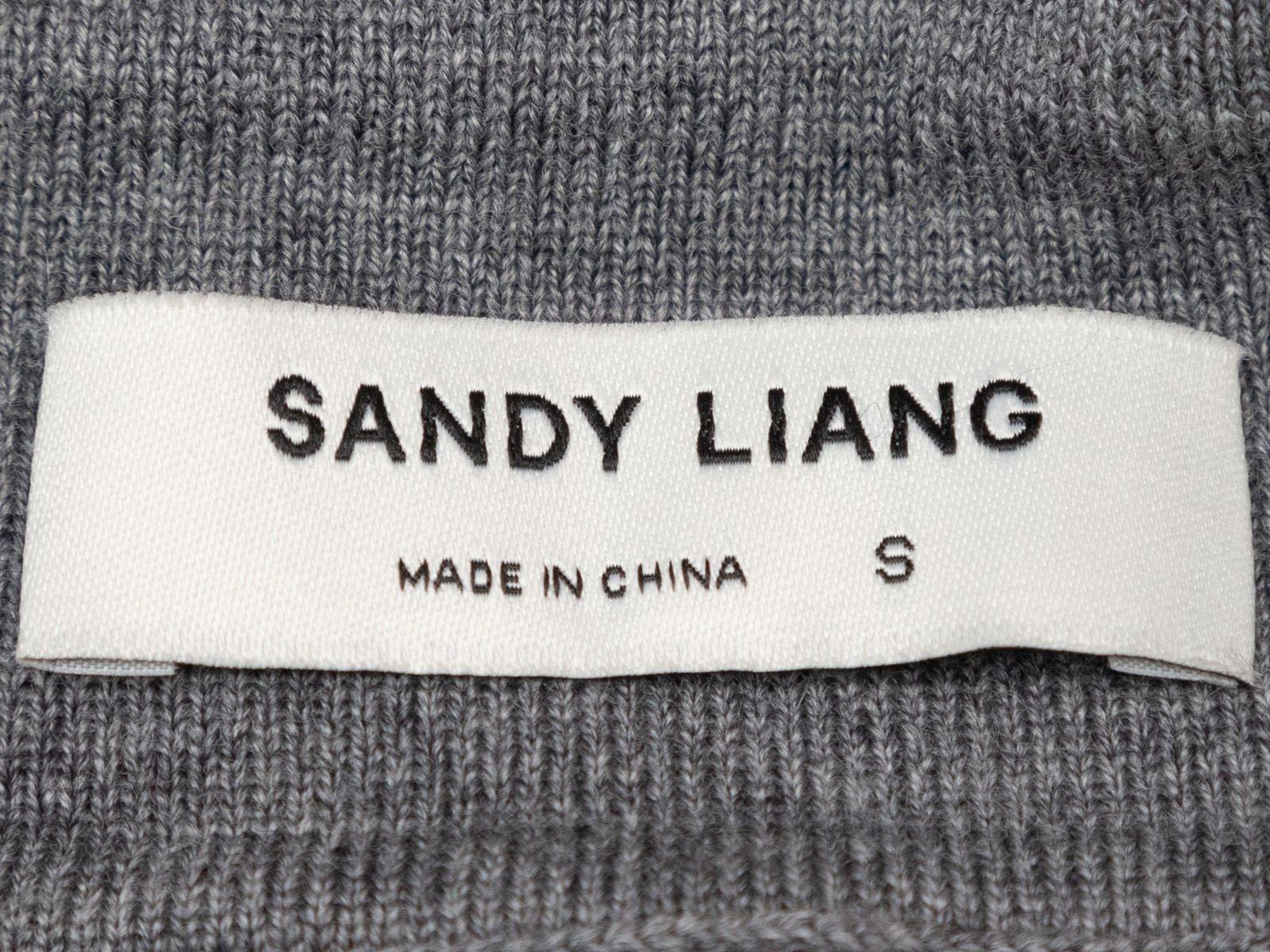 Product Details: Grey cropped merino wool polo sweater by Sandy Liang. Pointed collar. Long sleeves. Button closures at bust. 40