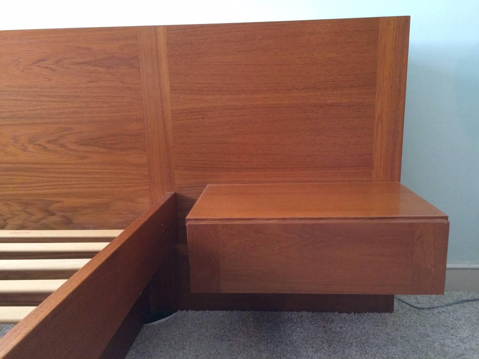 Danish queen-sized teak platform bed with detachable floating nightstands with single drawers. Made in Denmark circa 1972 by Sannemann Møbelfabrik. 

Headboard is 108 inches wide by 29.75 inches high. 

Total depth of the bed is 83